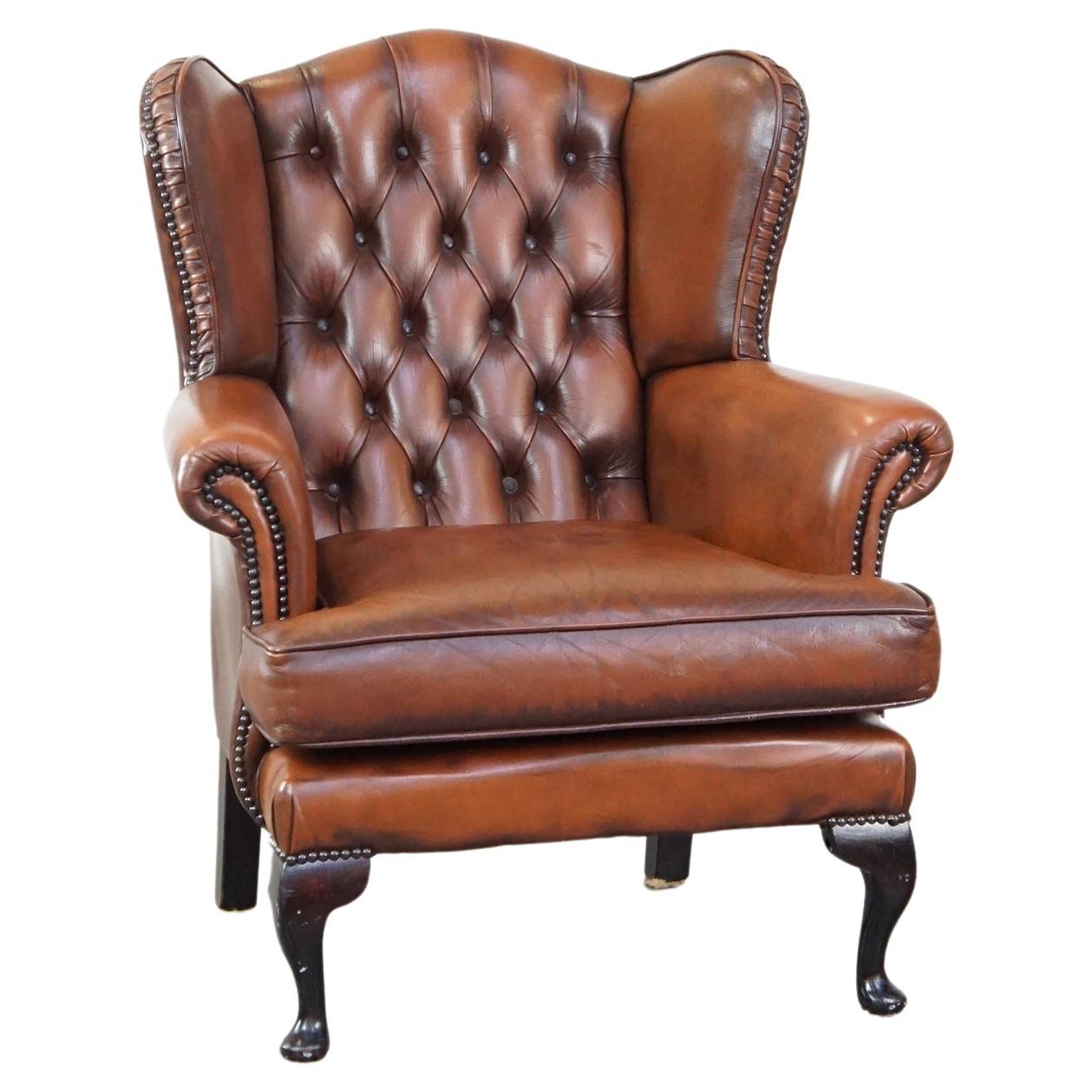Very beautiful cowhide Chesterfield wing chair with elegant legs in brown color