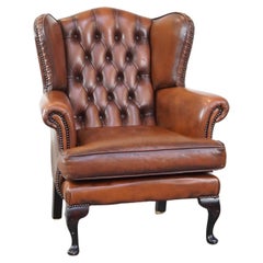 Very beautiful cowhide Chesterfield wing chair with elegant legs in brown color