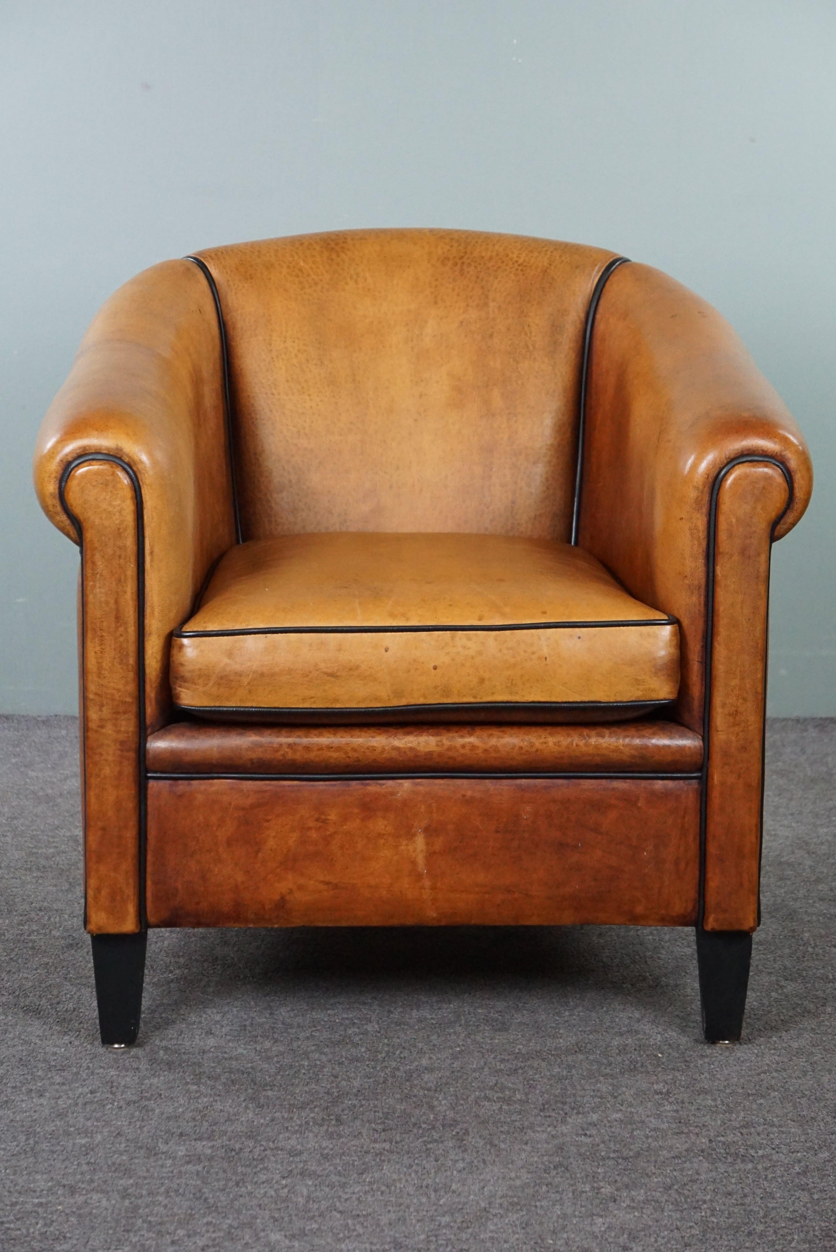 Offered is this elegant and well-maintained sheep leather club armchair. Here, we present to you a high-quality and stunning sheep leather club armchair. This armchair is in good condition and provides a wonderfully comfortable seat. With its
