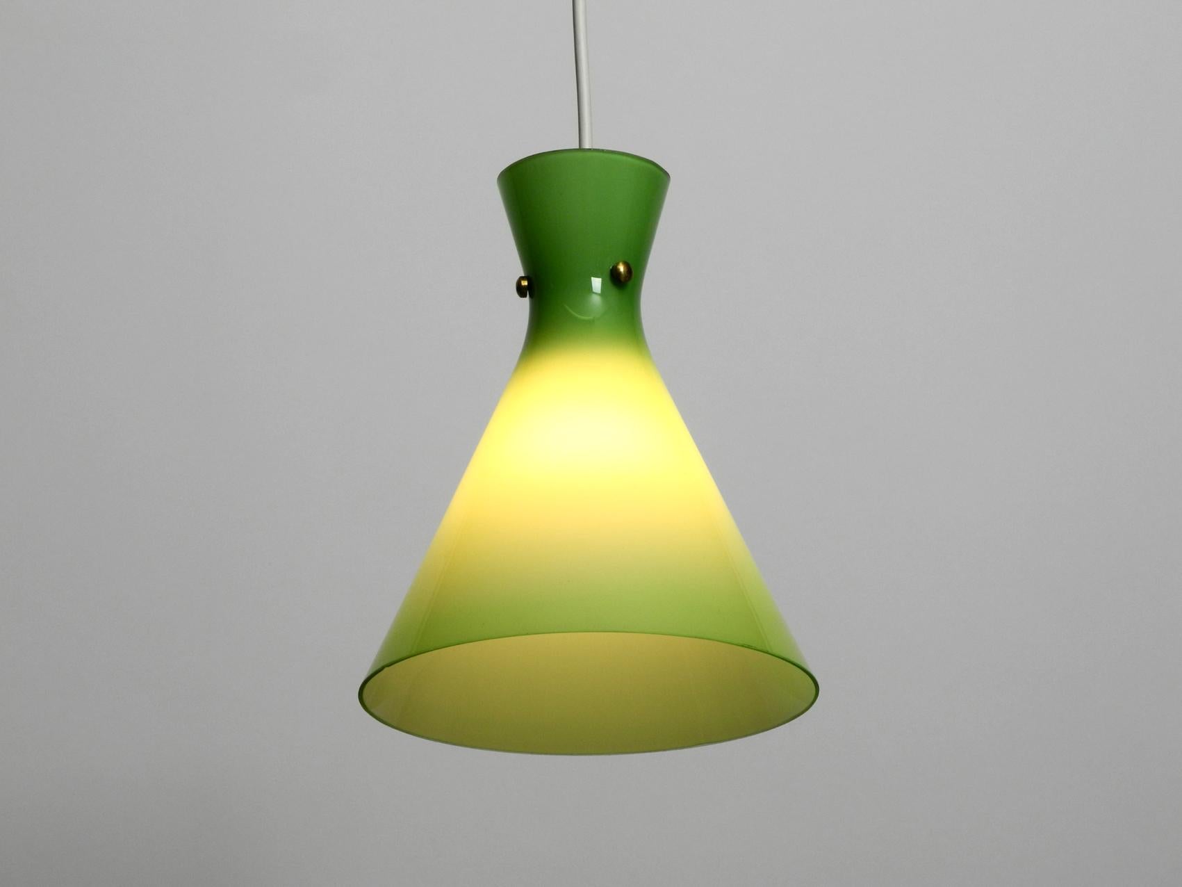 Very beautiful midcentury overglass Diabolo pendant lamp. Made in Austria.
The glass is outside light green and inside white. Rare and elegant Mid-Century Modern. Opaline glass pendant lamp.
One E27 light bulb. The lamp is in a very good original