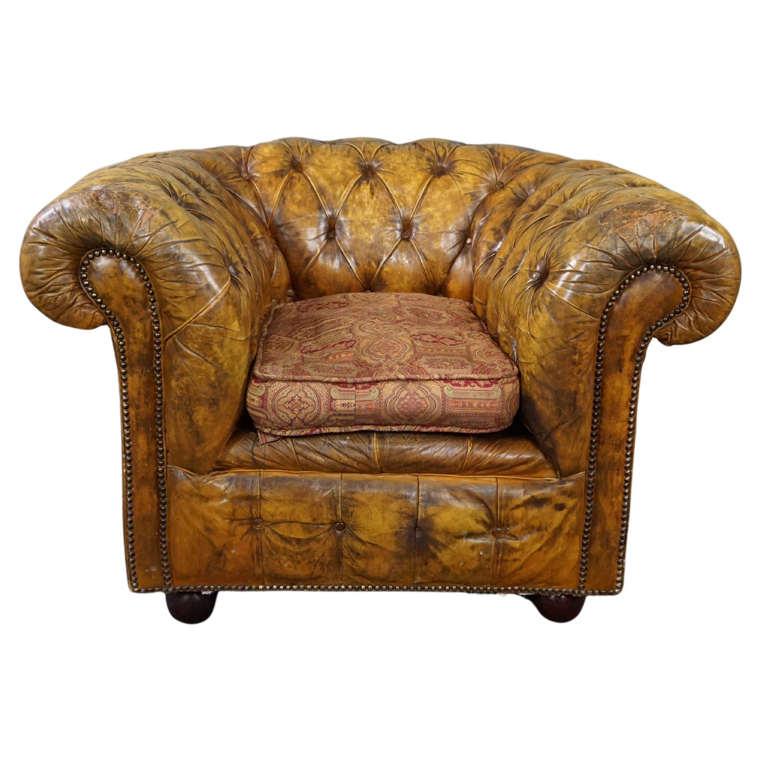 Very beautiful old Chesterfield armchair full of patina For Sale