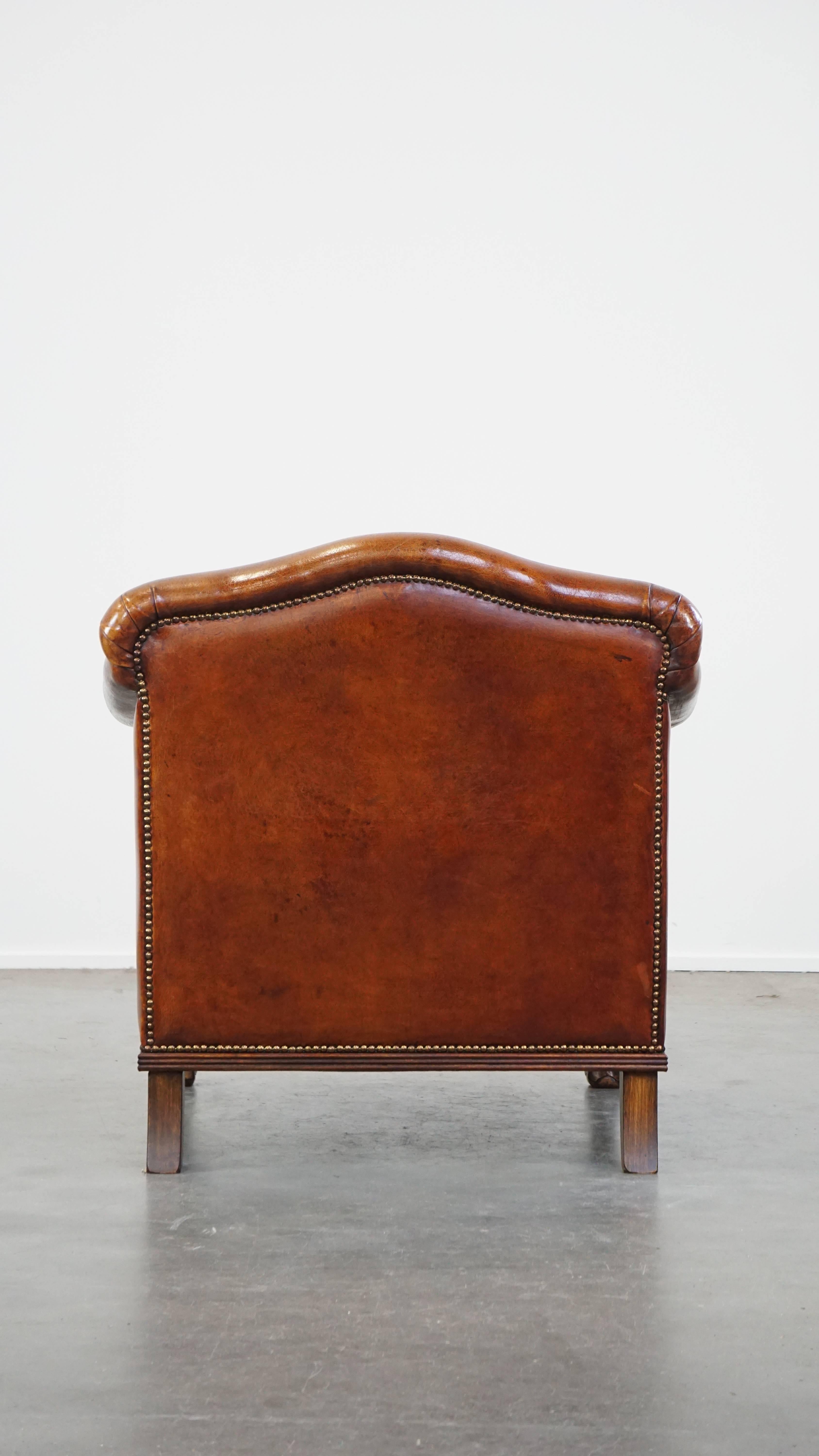 Very beautiful sheepskin armchair with an elegant design and wood-carved legs In Good Condition For Sale In Harderwijk, NL