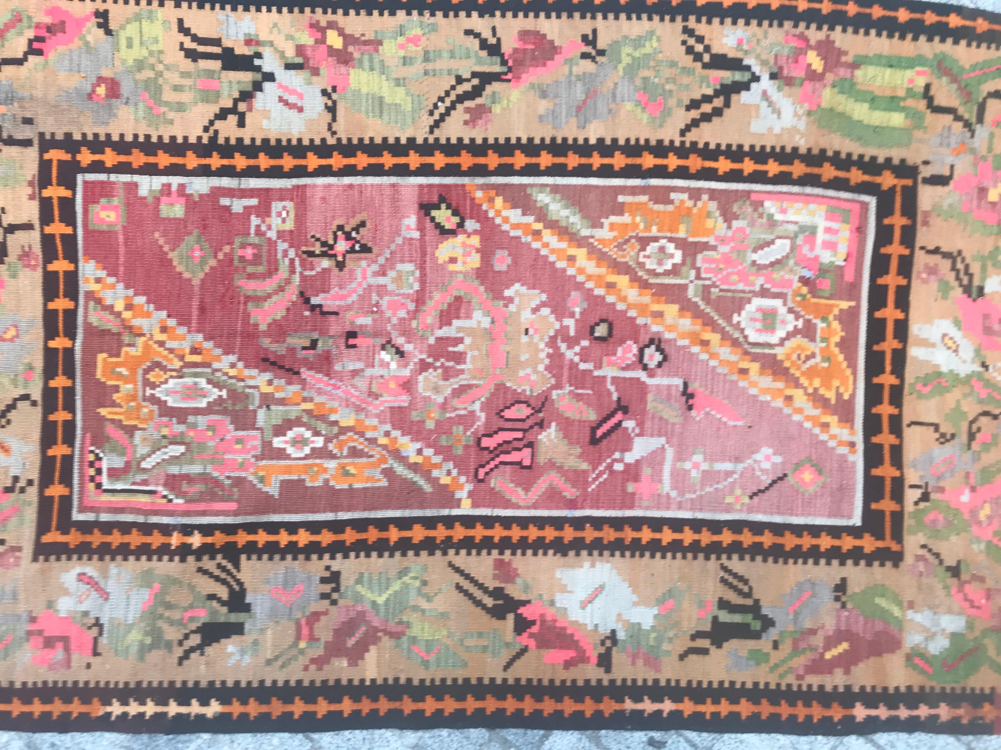 Nice mid-20th century Kilim with a beautiful decorative design and beautiful colors with pink, green, yellow, orange, black and blue, entirely handwoven with wool on cotton foundation.