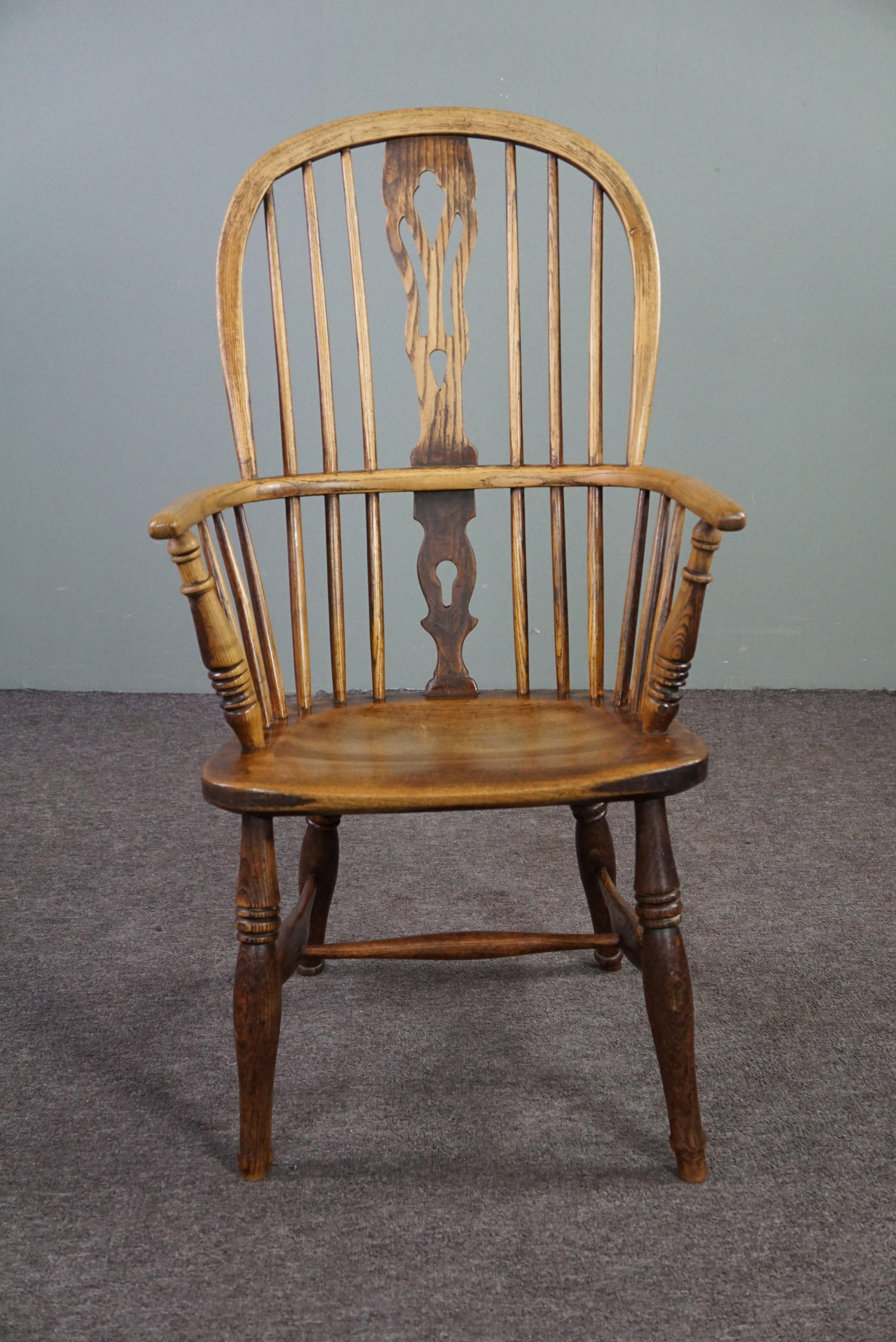 Cette belle chaise ancienne est en bois massif et présente une belle patine.

Cette élégante chaise Windsor anglaise de la fin du XVIIIe siècle possède un dossier à barreaux, une assise aux formes magnifiques et de beaux accoudoirs. La chaise a de
