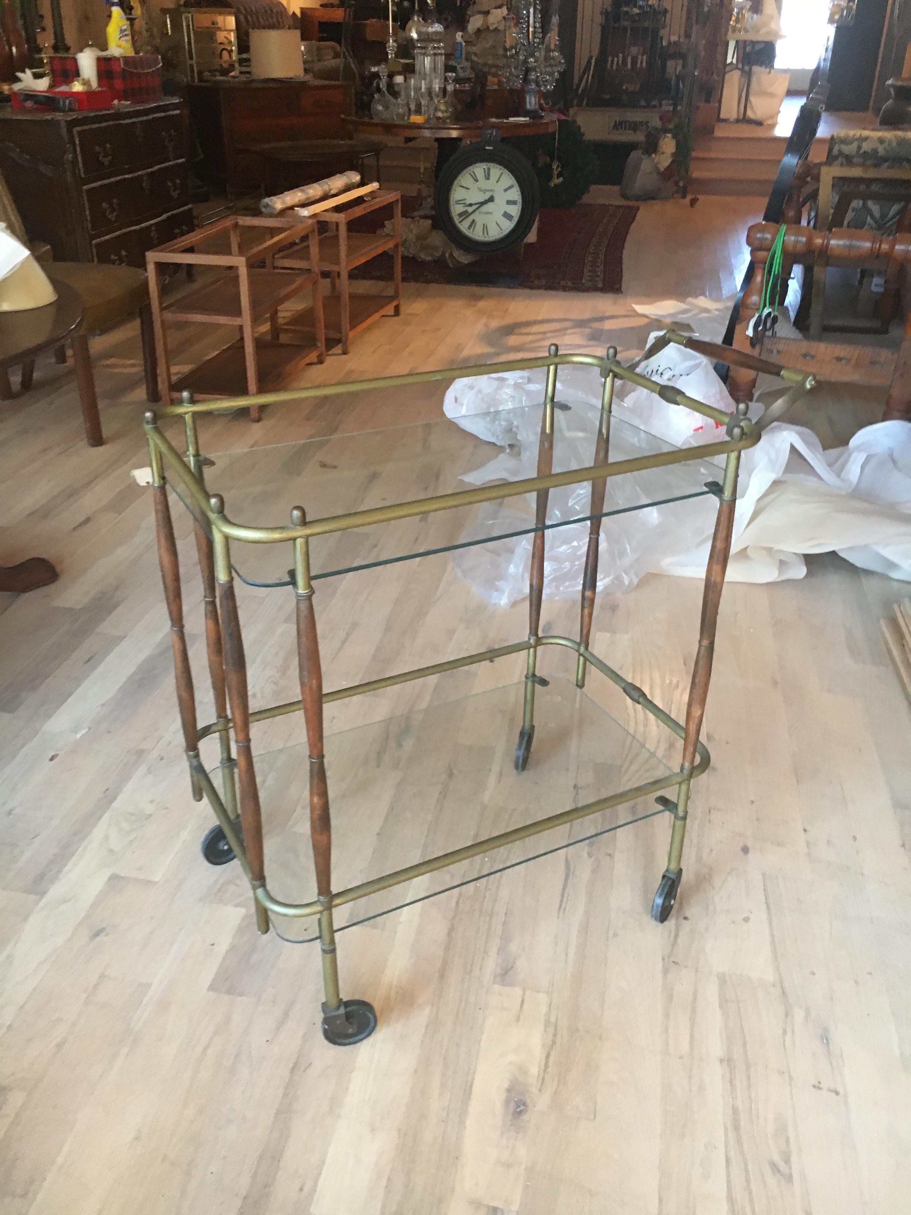 Very chic brass and walnut midcentury two-tier bar cart. Nice old patina, we have had it detailed so ready for installation.  Feel free to call with further questions.
Measures: 34
