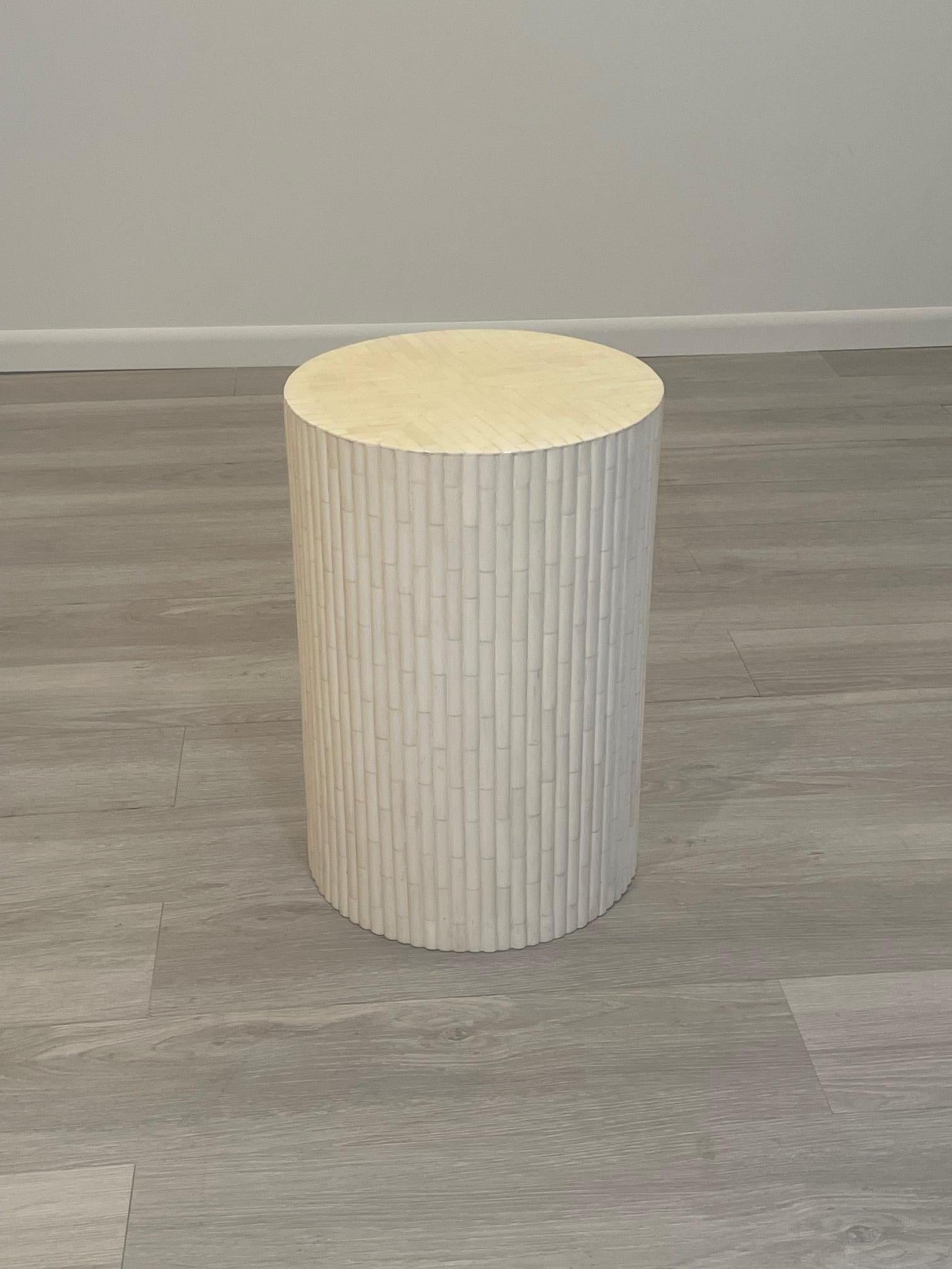 Chic sophisticated and versatile round cream colored tessellated round side drinks table having ribbed body that has a faux bamboo vibe.
