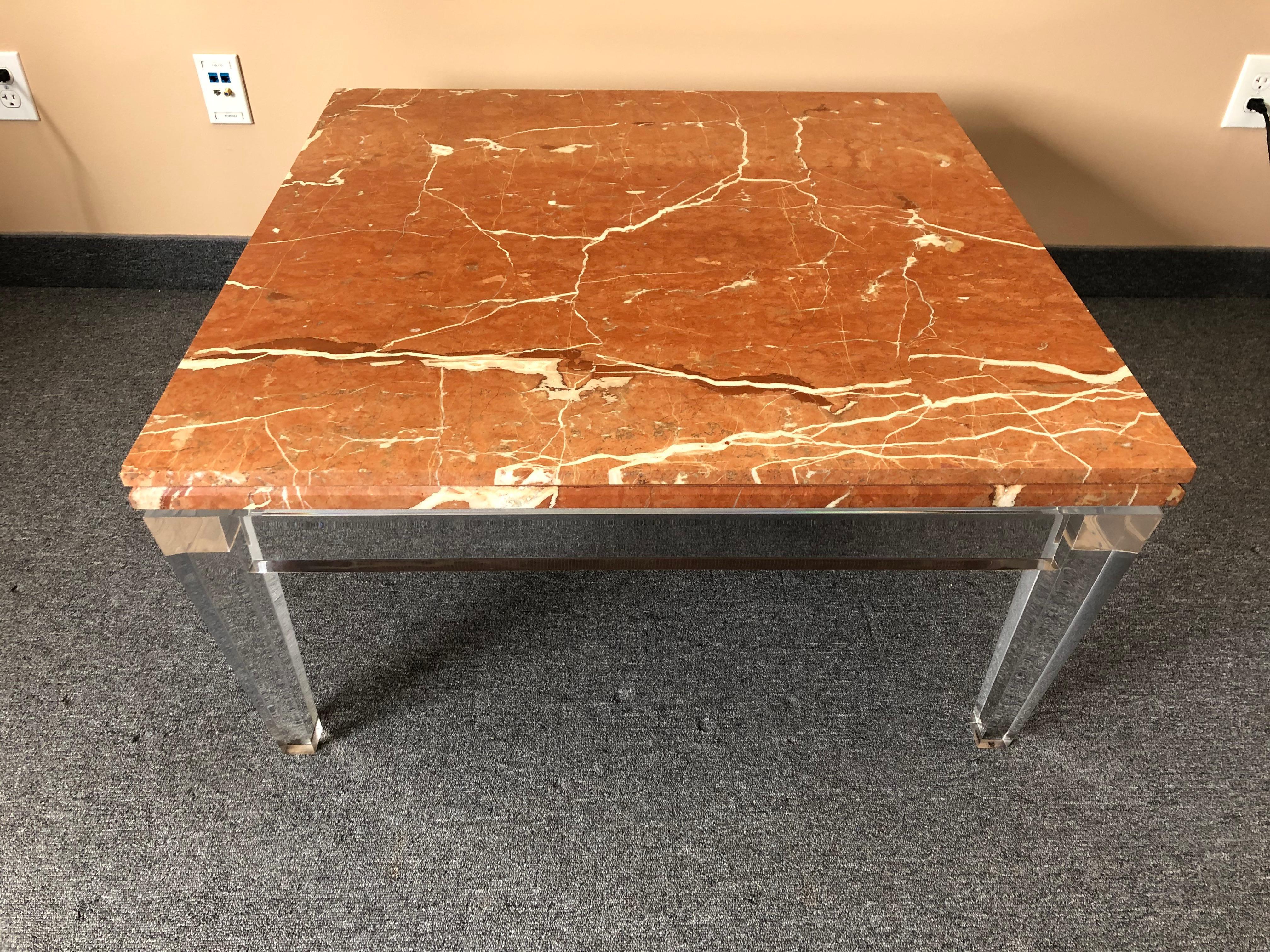 A rare gorgeous Mid-Century Modern coffee table that pairs a clear Lucite base that seems to float underneath a heavy slab of terracotta and cream marble top. One of a kind elegant and glamorous focal point.
