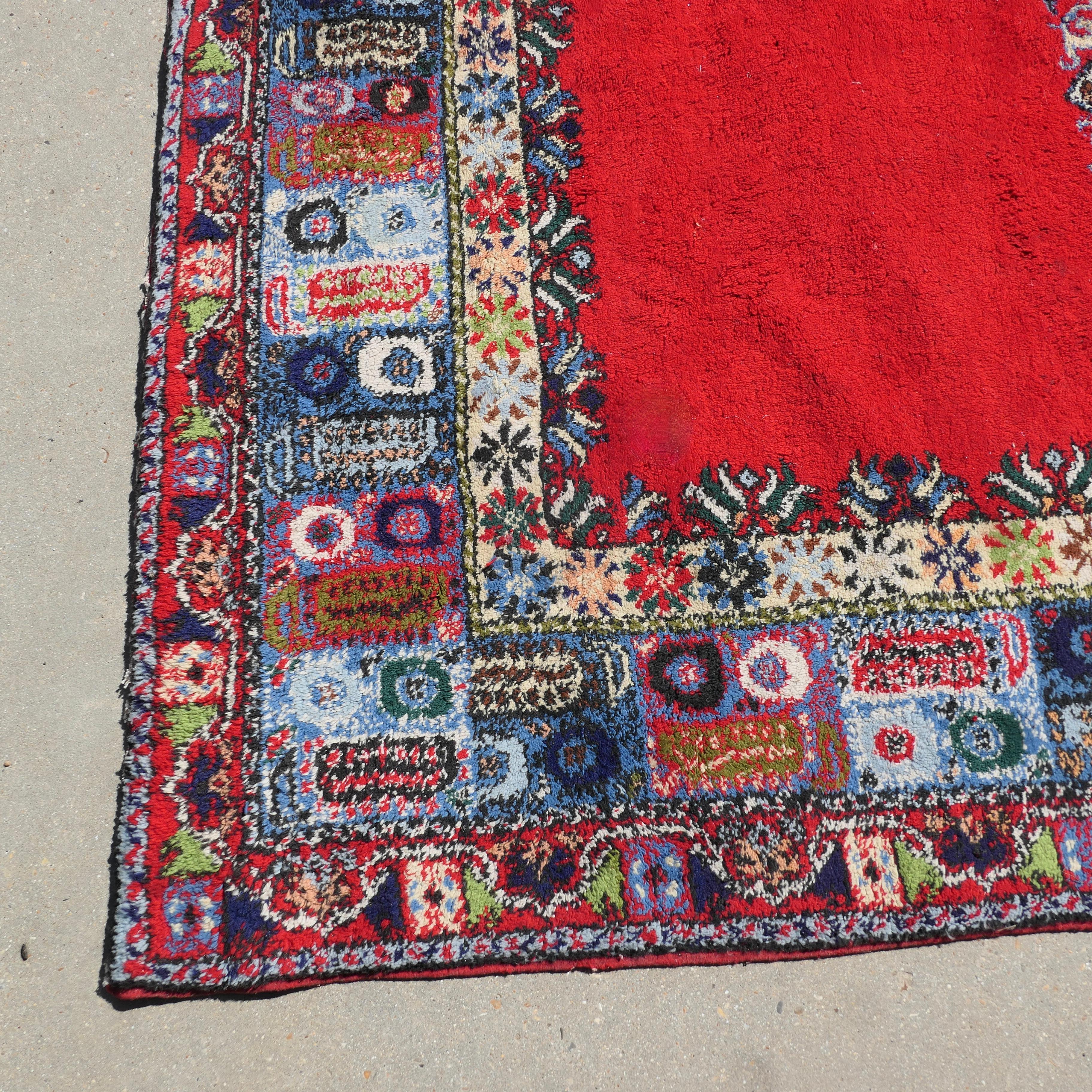 Tapis traditionnel très coloré  

Une pièce superbe, très épaisse, avec un centre rouge vif entouré d'une large bordure traditionnelle colorée en bleu pour compléter le rouge. 
Le tapis est en laine et date du début du 20ème siècle. Il est en bon