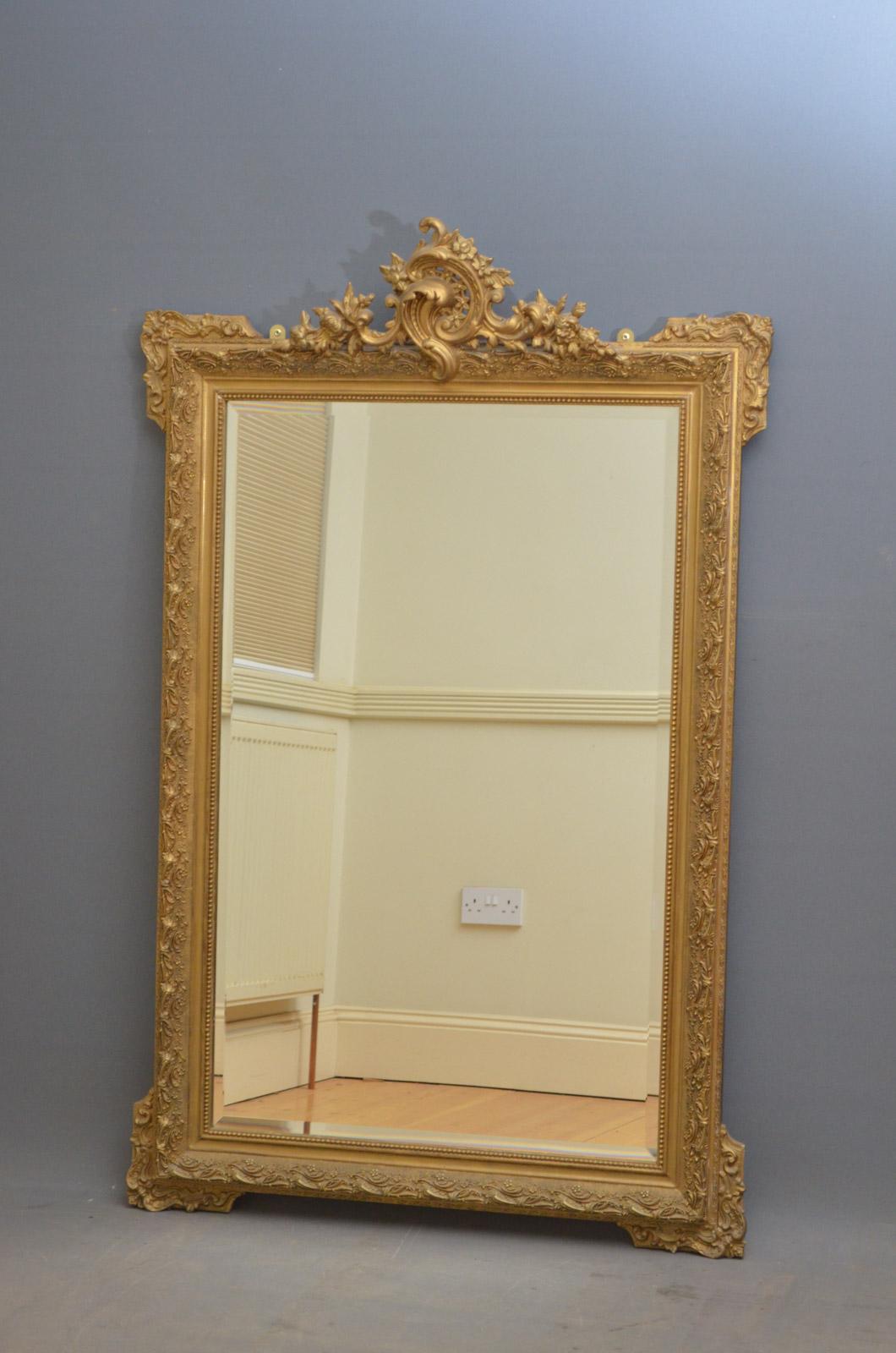 Sn4412 großer Wandspiegel aus vergoldetem Holz, mit außergewöhnlicher Verzierung mit Rollen, Blumen und Blättern auf der Oberseite und originaler, abgeschrägter Spiegelplatte in fein geschnitztem Rahmen. Dieser Spiegel wurde in der Vergangenheit