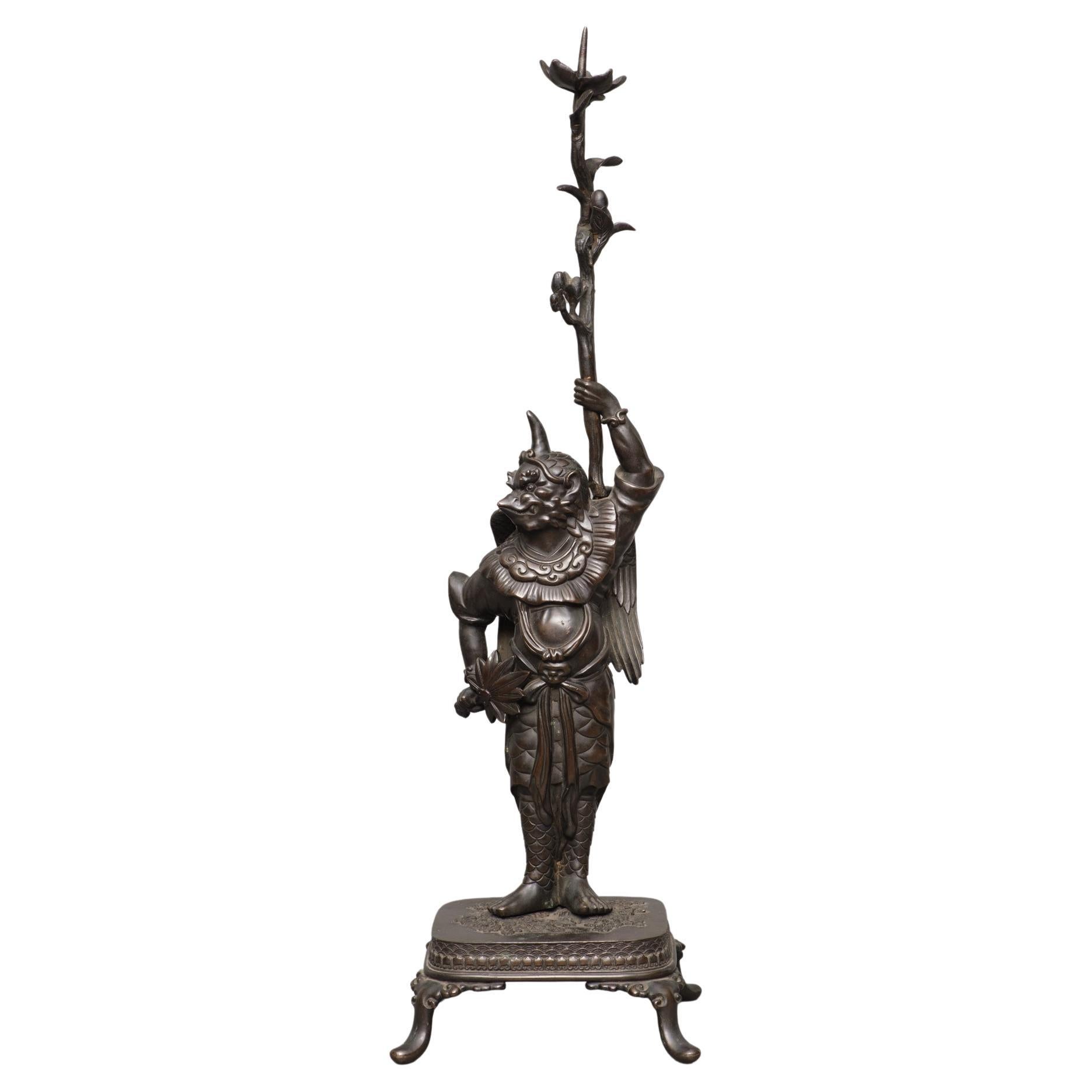Okimono japonais en bronze représentant un 'Karasu Tengu' 鴉天狗 tenant une branche de fleur en vente