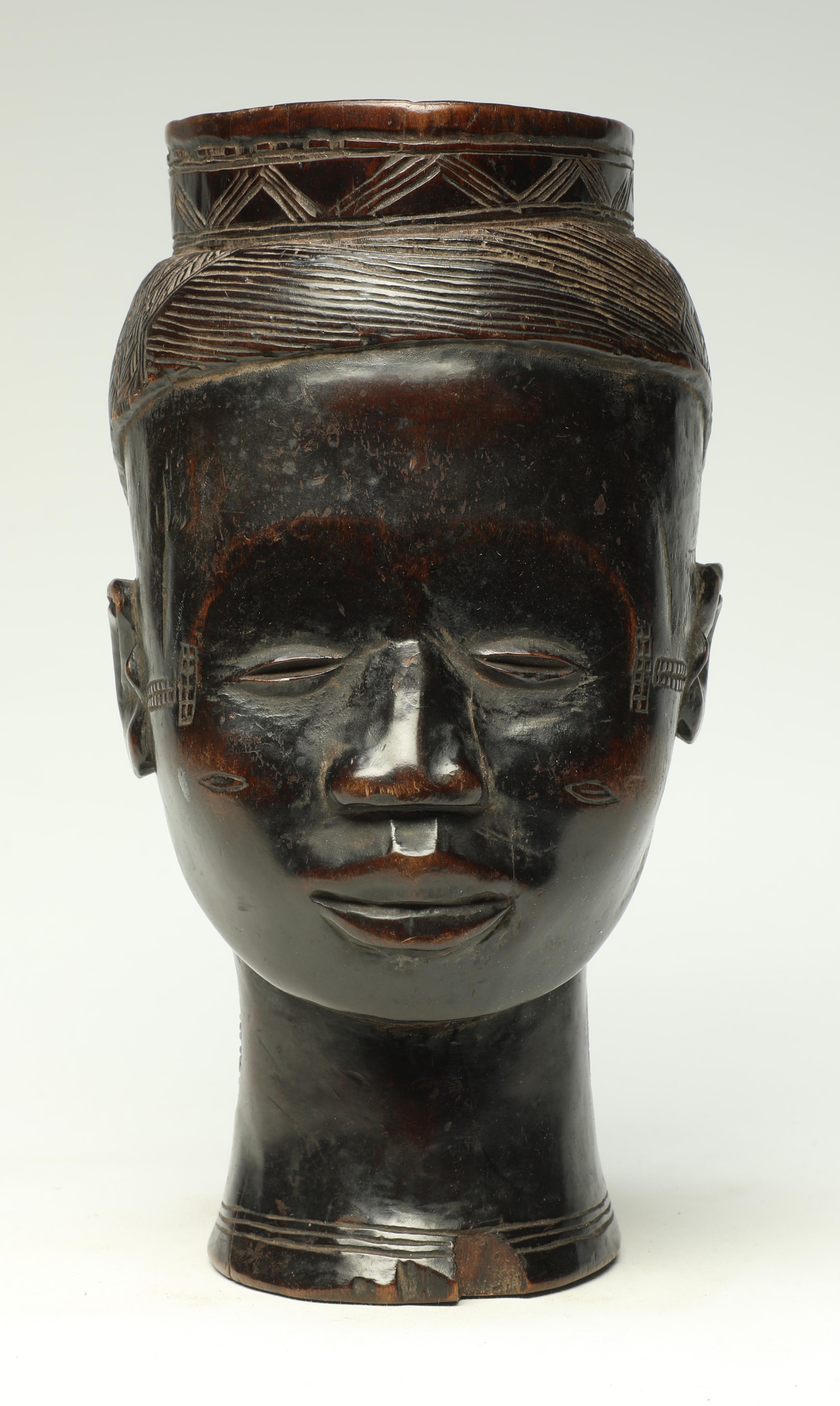Early finely carved hard wood Kuba figural cup, Congo with rich and deep patina. In the form of a naturalistic sweet face and handle on back. Wonderful asymmetrical incised classic Kuba crisscross design for hair. Very deep patina, wear and polish