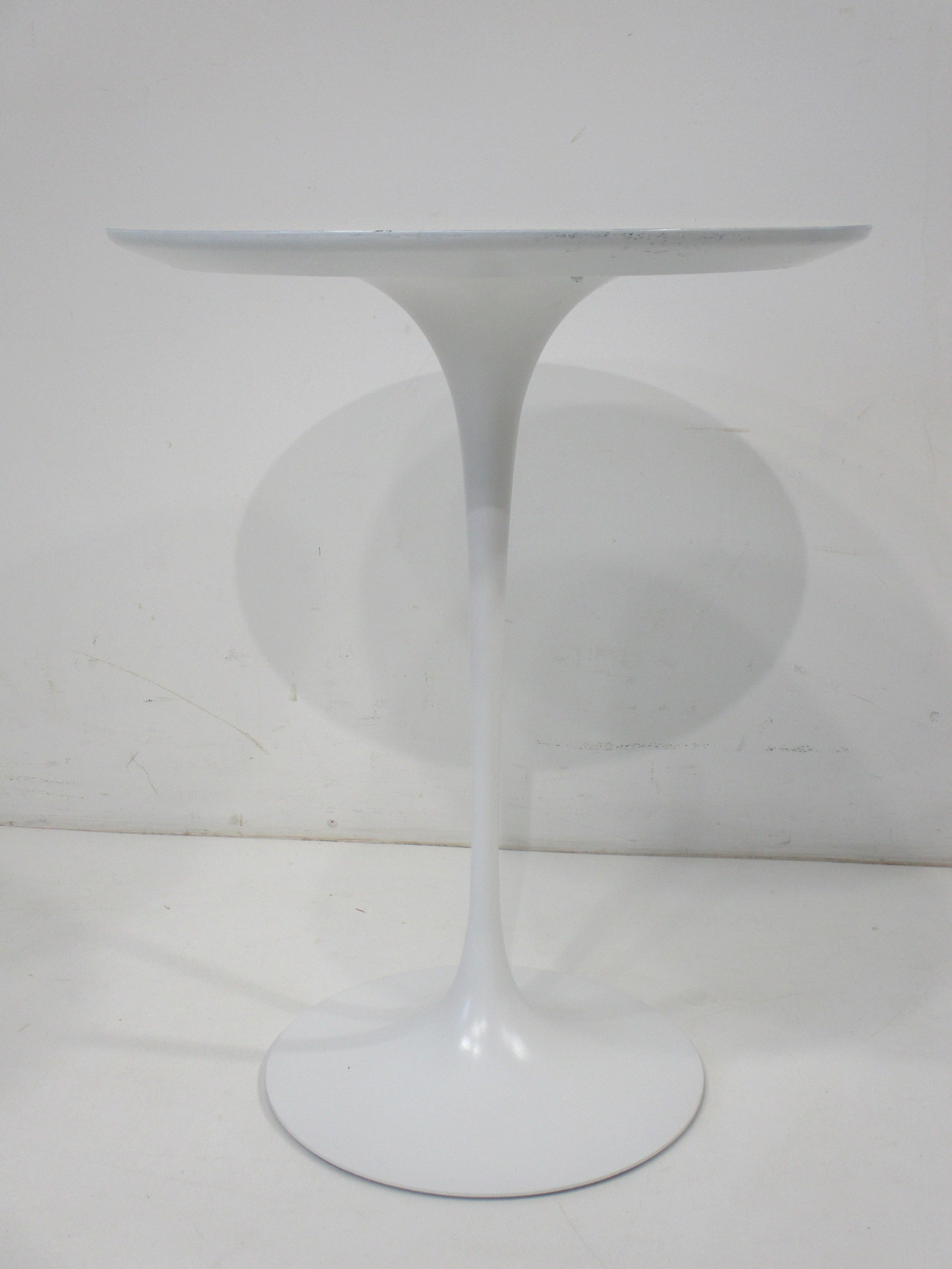 A very fine sculptural tulip side table with a round top in white Laminate and matching colored base . A very early production piece with solid steel base manufactured by Knoll and designed by Eero Saarinen , an iconic piece that will fit in any