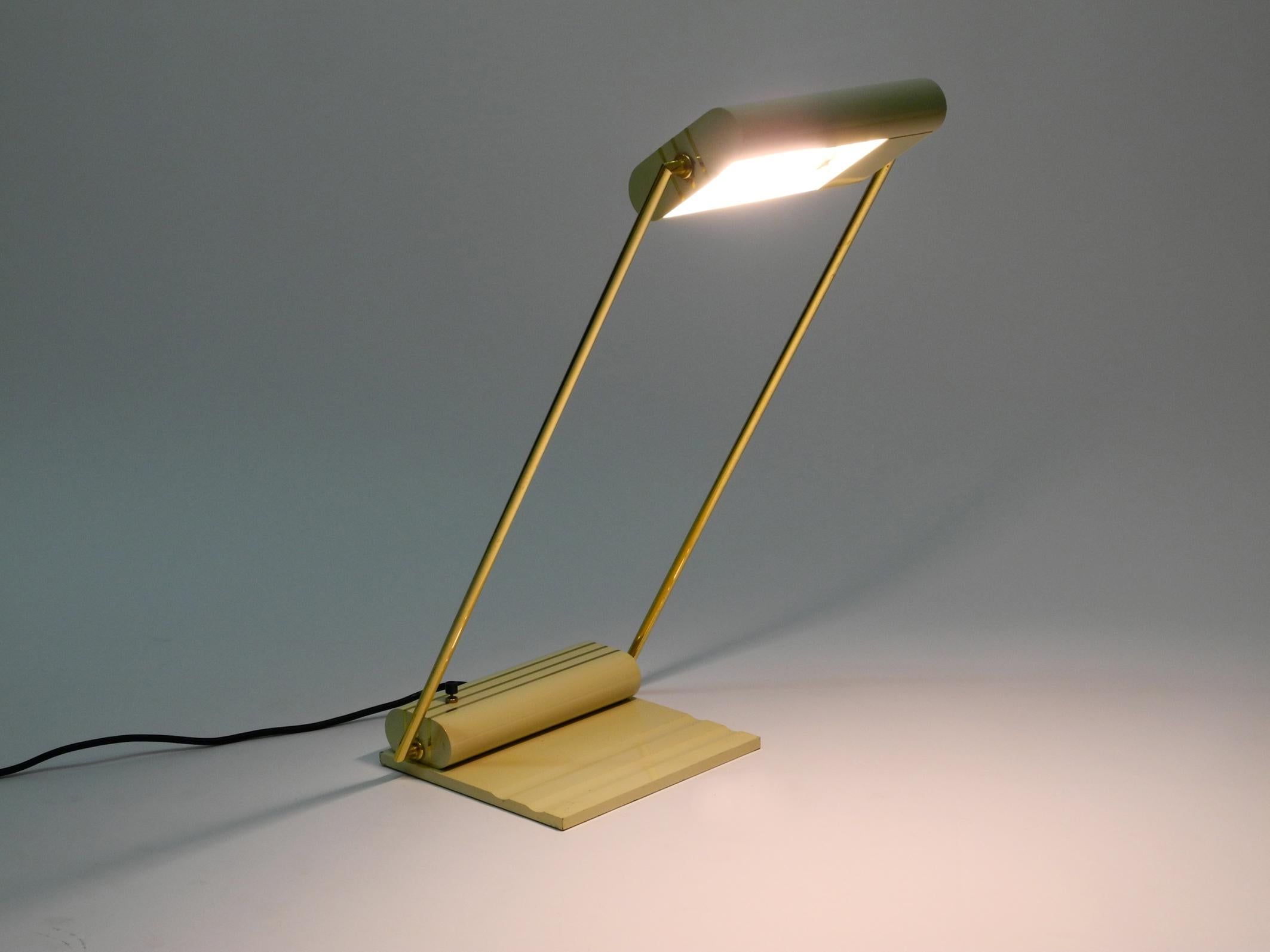 Very elegant 1980s large metal table lamp from Italy.
Great minimalistic postmodern design.
Heavy metal foot, shade also made of metal.
Both rods holding the shade are made of brass.
Shade and brass holders are steplessly movable.
Very well