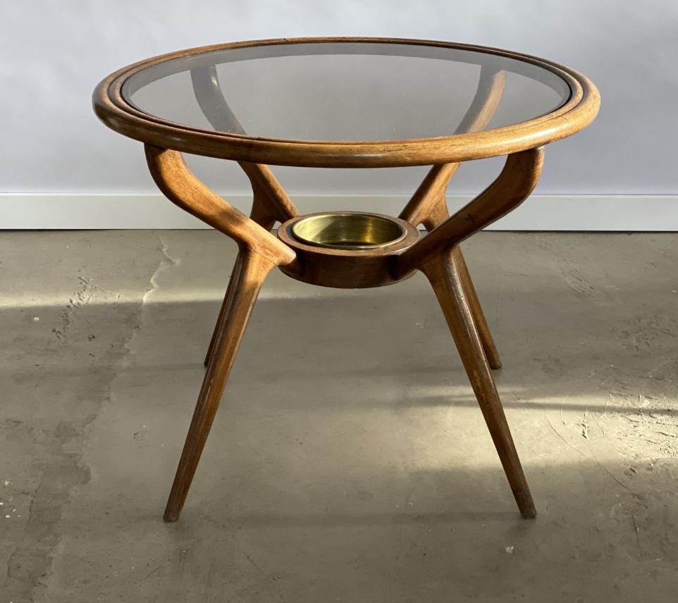 Beautifully shaped medium-sized Italian coffee table with a round lightly bronze-tinted round glass top. This is a ty[ical Italian design very much in the fashion of Gio Ponti, Cesare Lacca or Vittorio Dassi; approximately from the end 1940s. Under