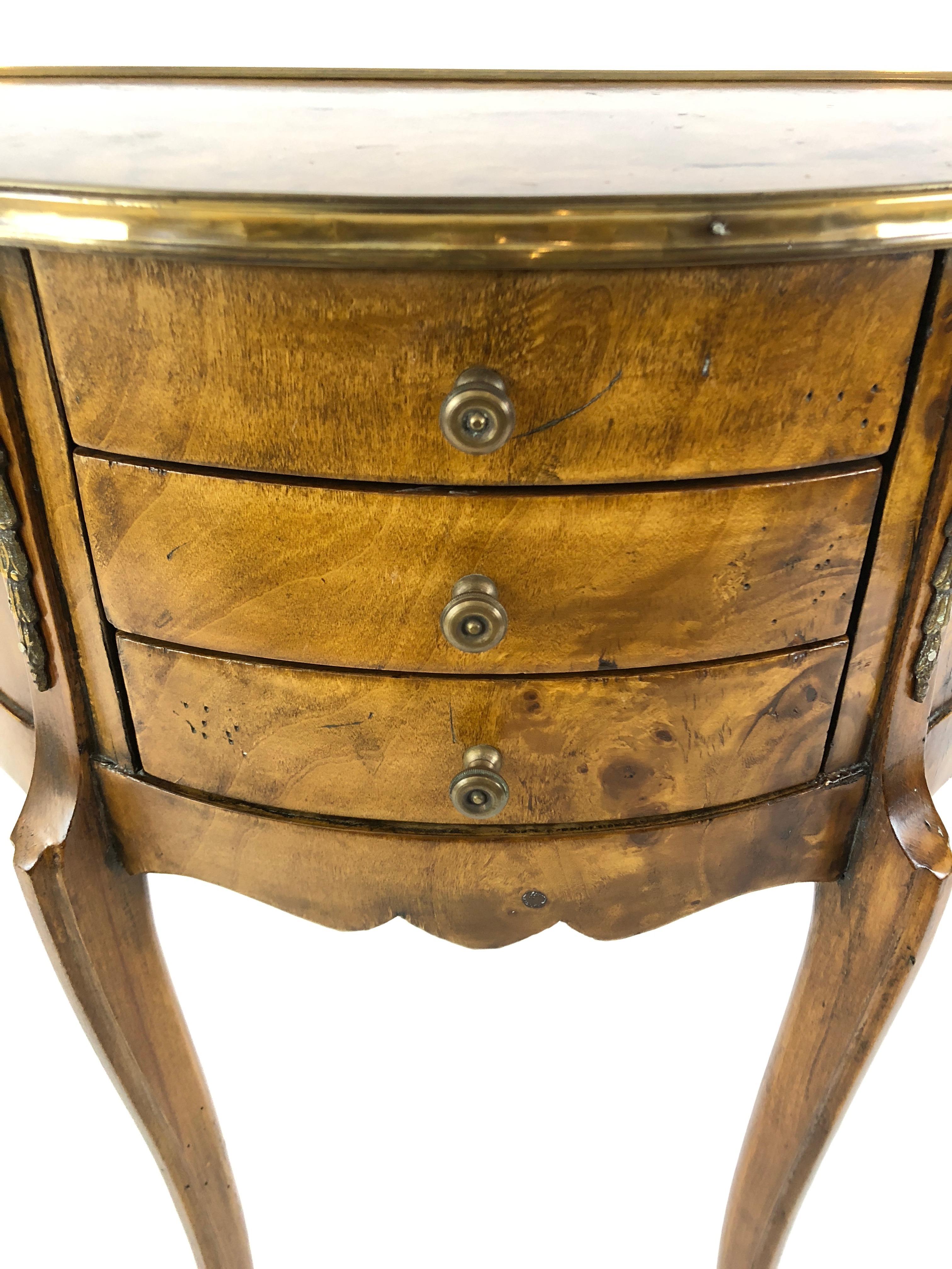 Gorgeous burl wood demilune commode having brass frame around the top, lovely brass embellishments, 3 drawers, elegant cabriole legs with brass caps and finished on the back.