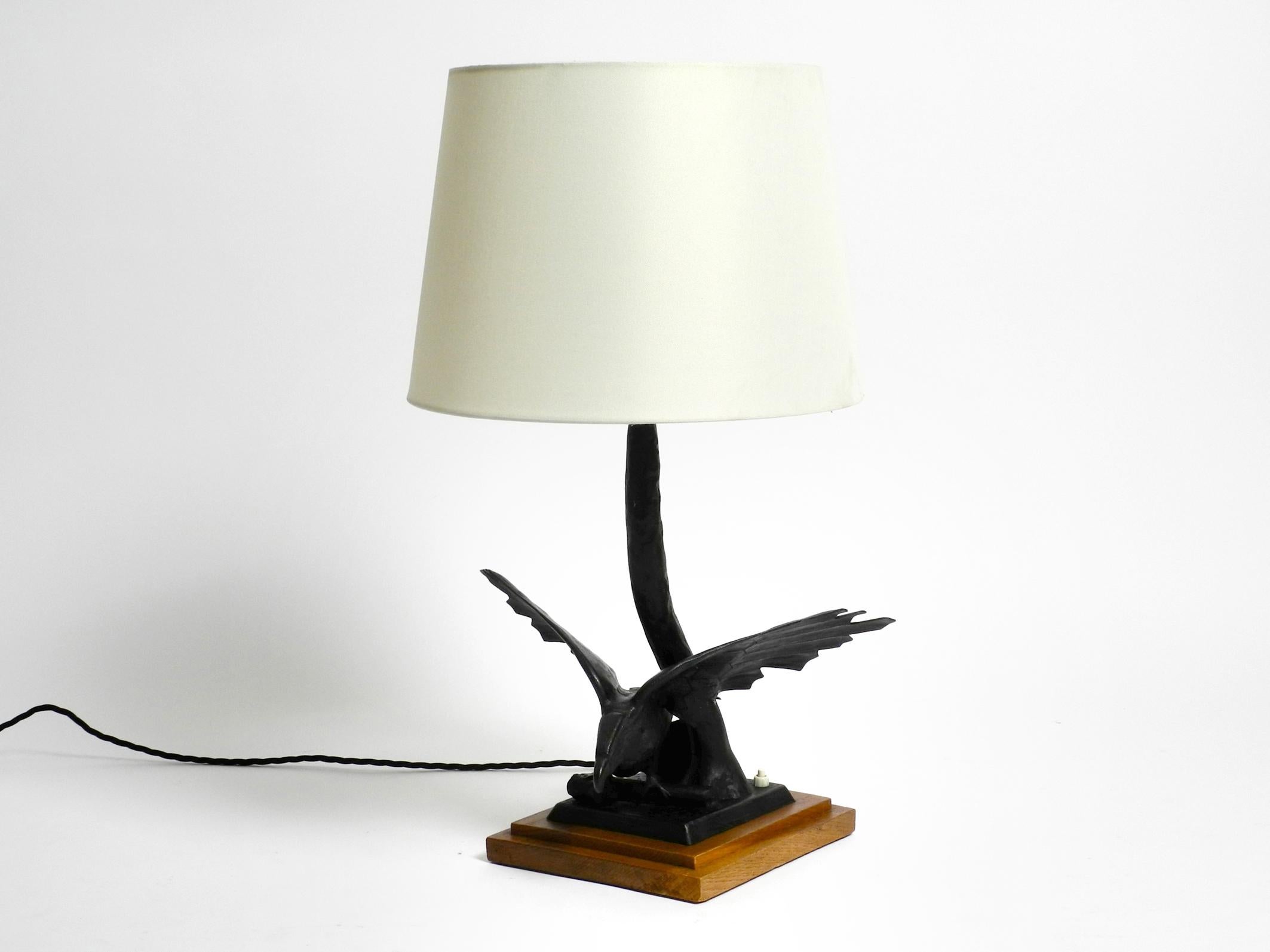 Very elegant large 1940s iron table lamp in the shape of an eagle with a teak base.
Great pre-war design. The complete eagle is made of iron in black.
Most likely from an Italian production.
Without damages to the eagle and original wooden