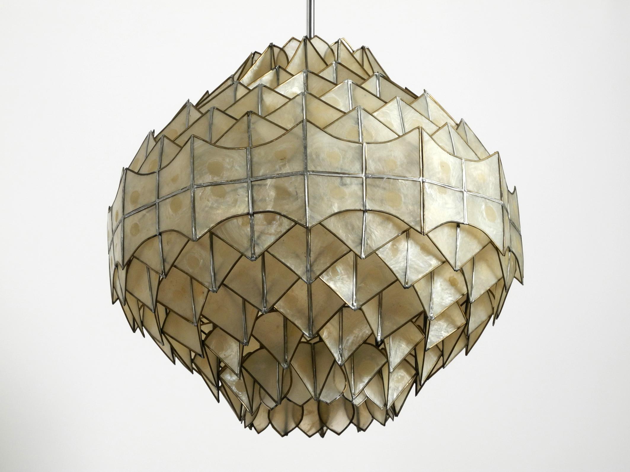 Very elegant stunning beautiful large pendant lamp made of mother of pearl.
Great rare design from the 1970s. Hard to find in this shape and condition
Very high quality workmanship. Metal frame, chrome-plated rod and chrome-plated canopy. Pleasant
