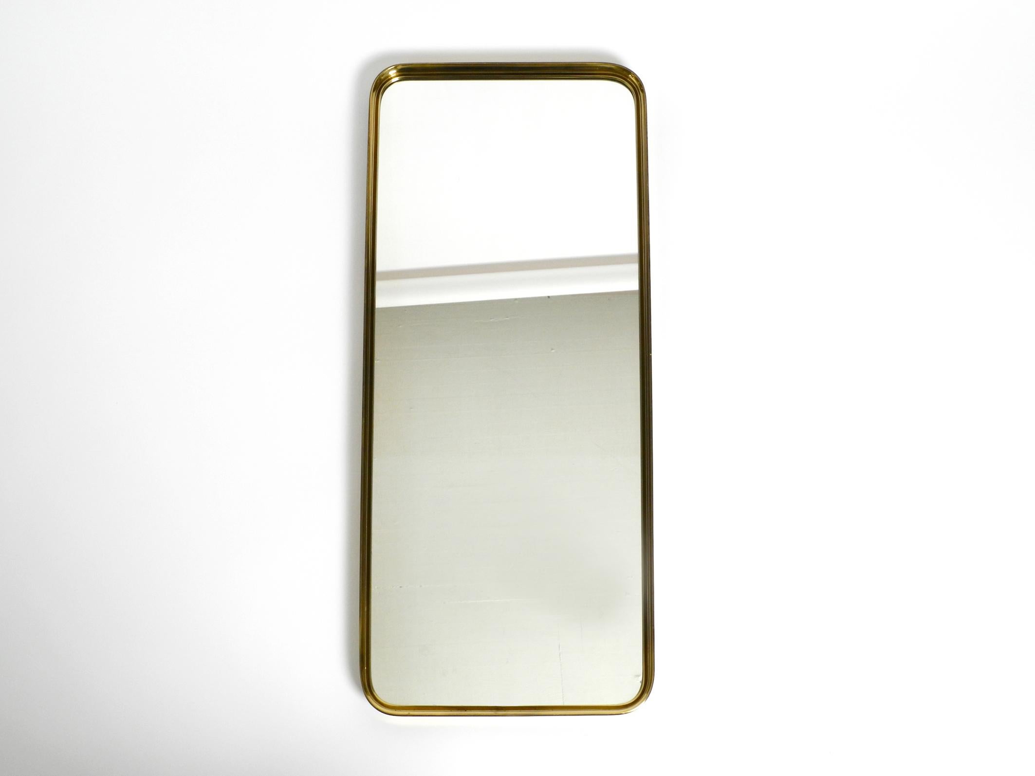 Beautiful Mid Century brass wall mirror by Vereinigte Werkstätten. Made in Germany. Great 1950's minimalist design.
High-quality workmanship and very solidly built. Weight about 5 kg.
Very good condition with no damage to the glass or