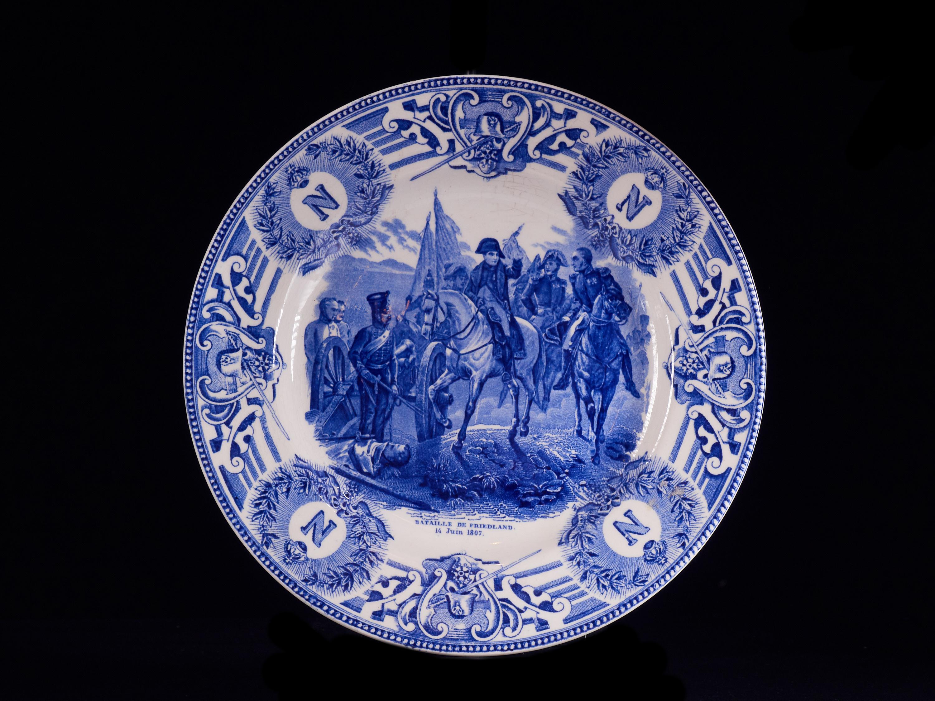 Wonderful set of 4 white faïencerie plates from the 1920s-1930s depicting major French battle scenes of the late 18th and early 19th century. The items are superbly painted with stamped indigo blue designs based on a 