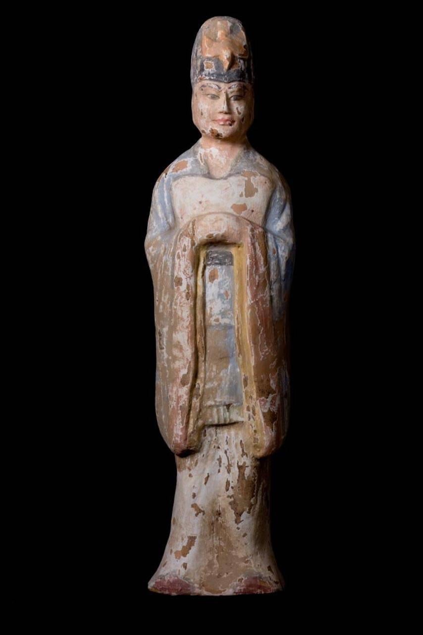 Dignatario de terracota muy elegante, vestido con túnicas azules y rojas, de pie y con las manos juntas en el pecho. Lleva un tocado azul con un pájaro en el centro. Naranja terracota

Esta magnífica pieza va acompañada de los siguientes documentos: