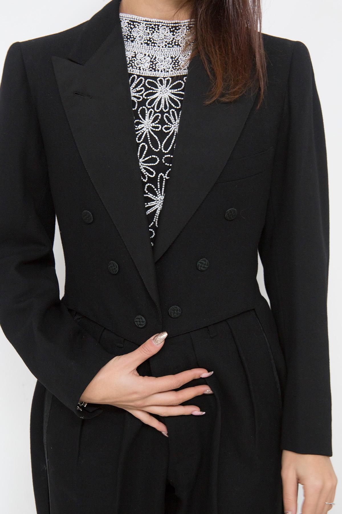 Gorgeous elegant two-piece black wool tight suit, very elegant.
The suit consists of two pieces: the jacket and the pants. The pants are beautiful and simple, falling softly on the foot. The jacket on the other hand is very elegant: it is a