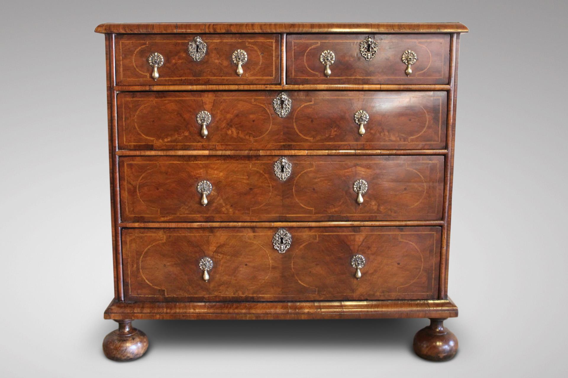 A very fine early 18th century, Queen Anne period walnut and oak with inlay chest of drawers of great colour & patina, moulded rectangular cross banded top above two short and three long graduated inlaid drawers, standing on original bun feet.