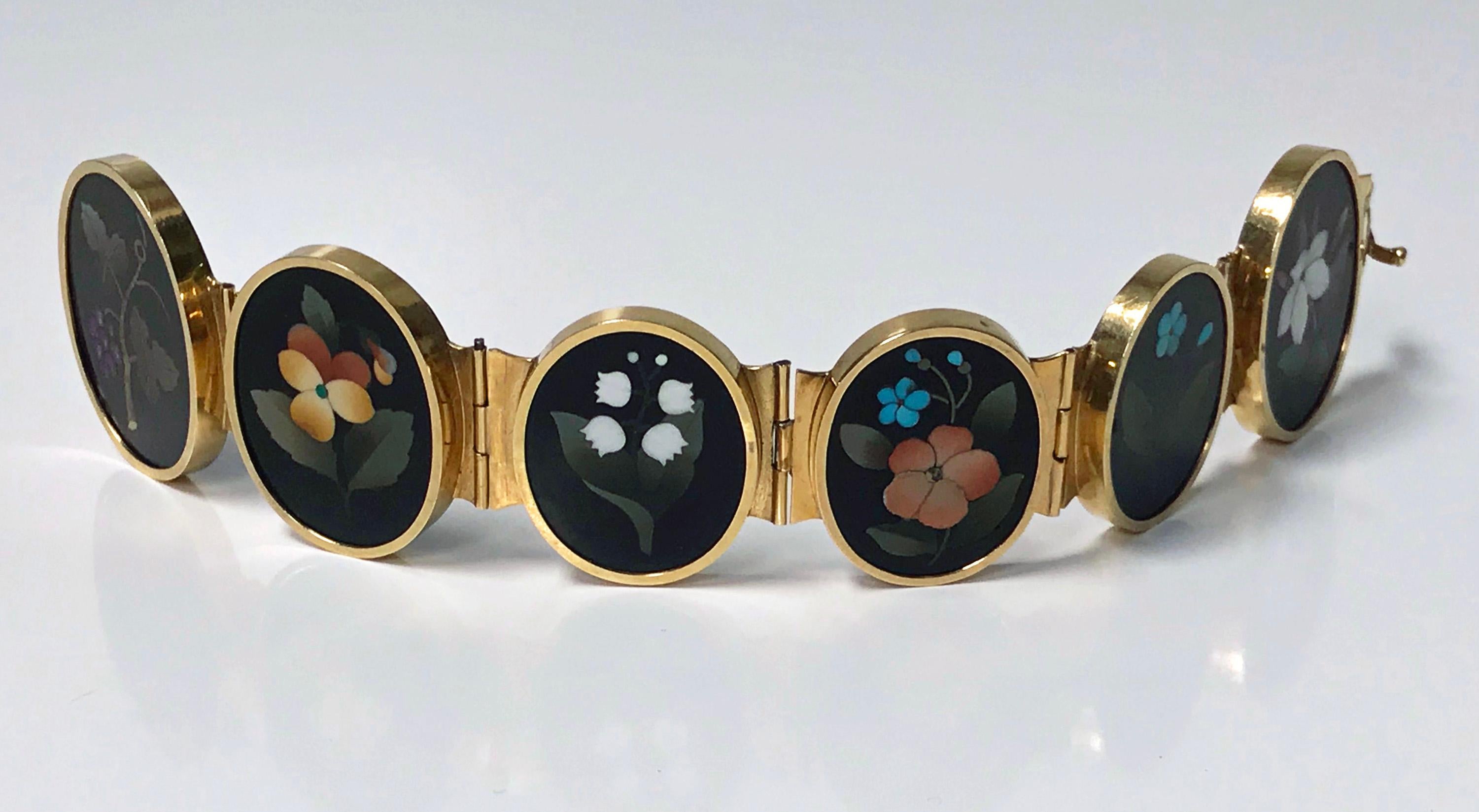 Very Fine 19th century 18K (tested) Gold Pietra Dura Bracelet, Italy C.1875. The bracelet with six slightly graduated oval bezel set pietra dura depicting foliage, berries and flowers, hinged gold links between, terminating with tongue box clasp