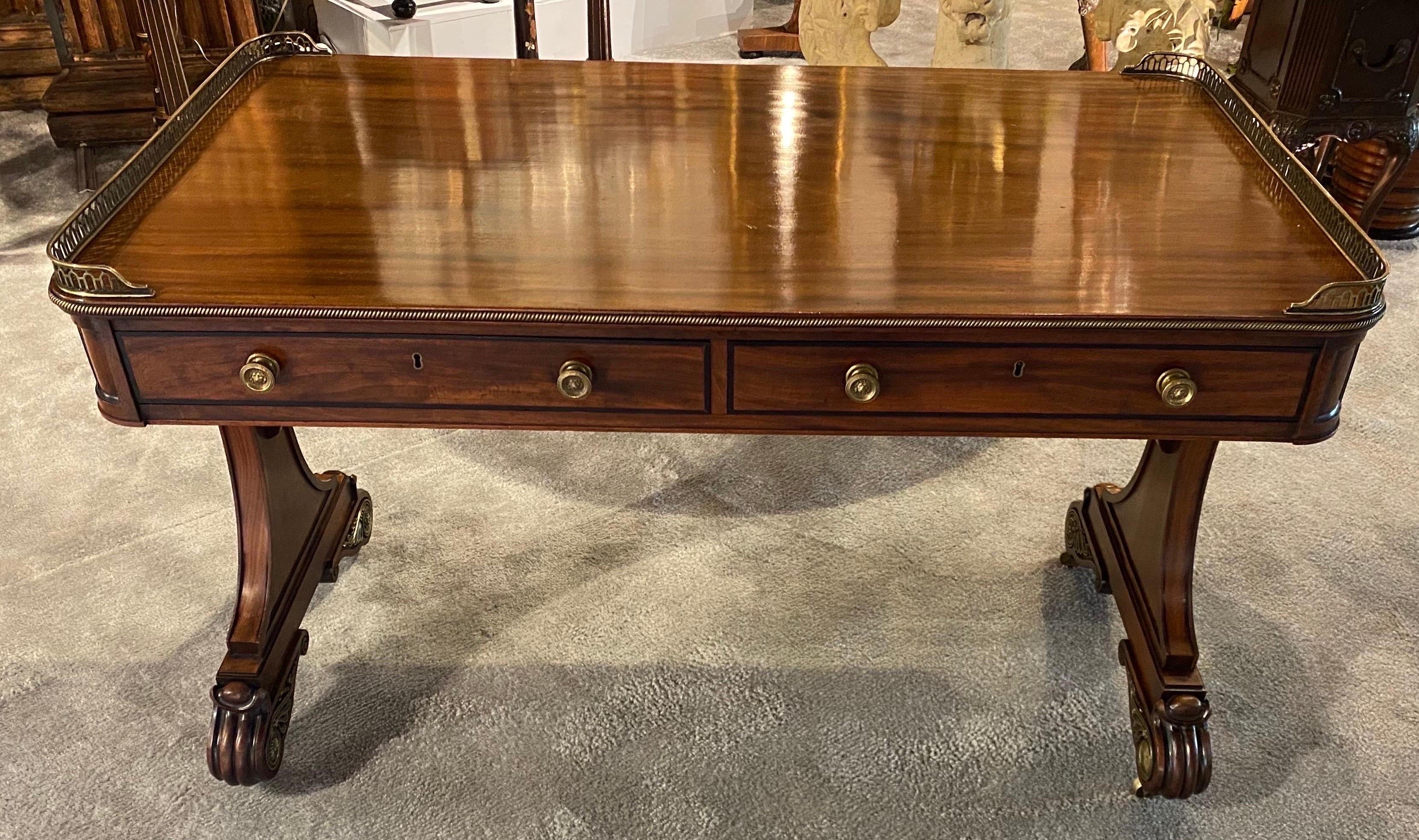 Very fine English Regency bronze mounted mahogany writing table. Single board top made of beautiful mahogany timber, with brass gallery flanking the sides atop of 2 mahogany lined drawers. The legs terminate into fully developed regency feet with