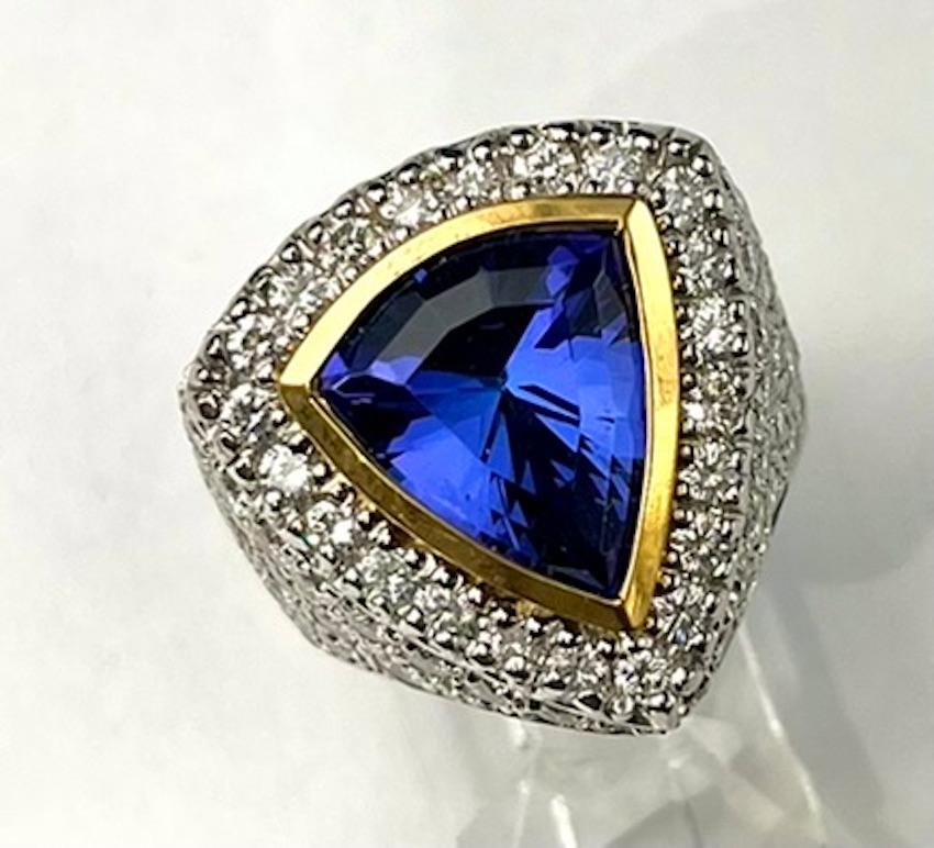 This amazing Tanzanite Ring features a beautiful Triangle Cut Tanzanite that is a rich and vibrant purple blue hue. While having great depth of color, this gem quality Tanzanite is also clear and lucid. The design of the ring is artistic and