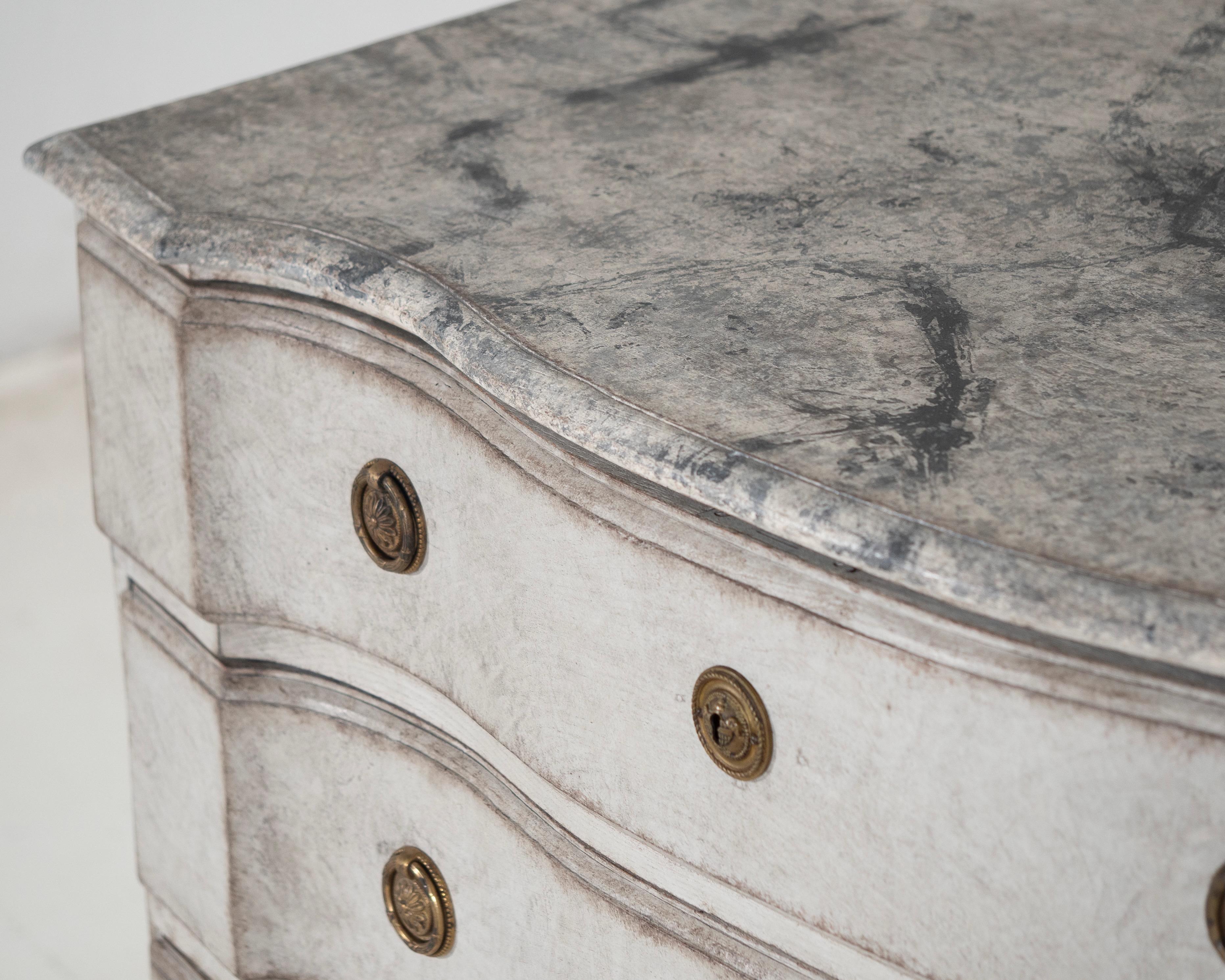 Very fine and rare chest of drawers with curved front and faux painted marble top, original side handles, circa 1750.