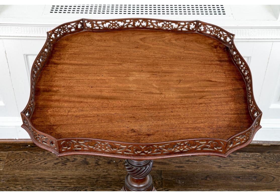 An antique Tea Table in notable condition with an elaborately  pierced full surround top edge, handsome figured Mahogany, well turned Column support with Spiral turned base element surmounting a traditional Tripod base terminating in a Pad foot. An