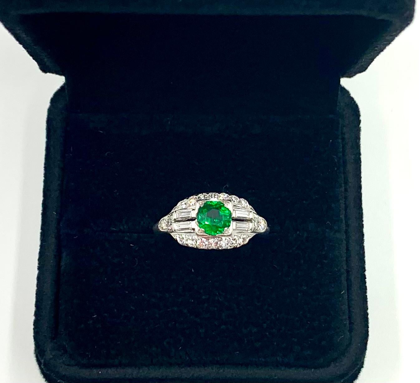 Superb Art Deco period demantoid garnet, diamond platinum engagement ring
Early 20th Century
The central round green garnet of very fine color, clarity and cut, approximately .80TCW, flanked by two baguette diamonds on each side and surrounded by 18