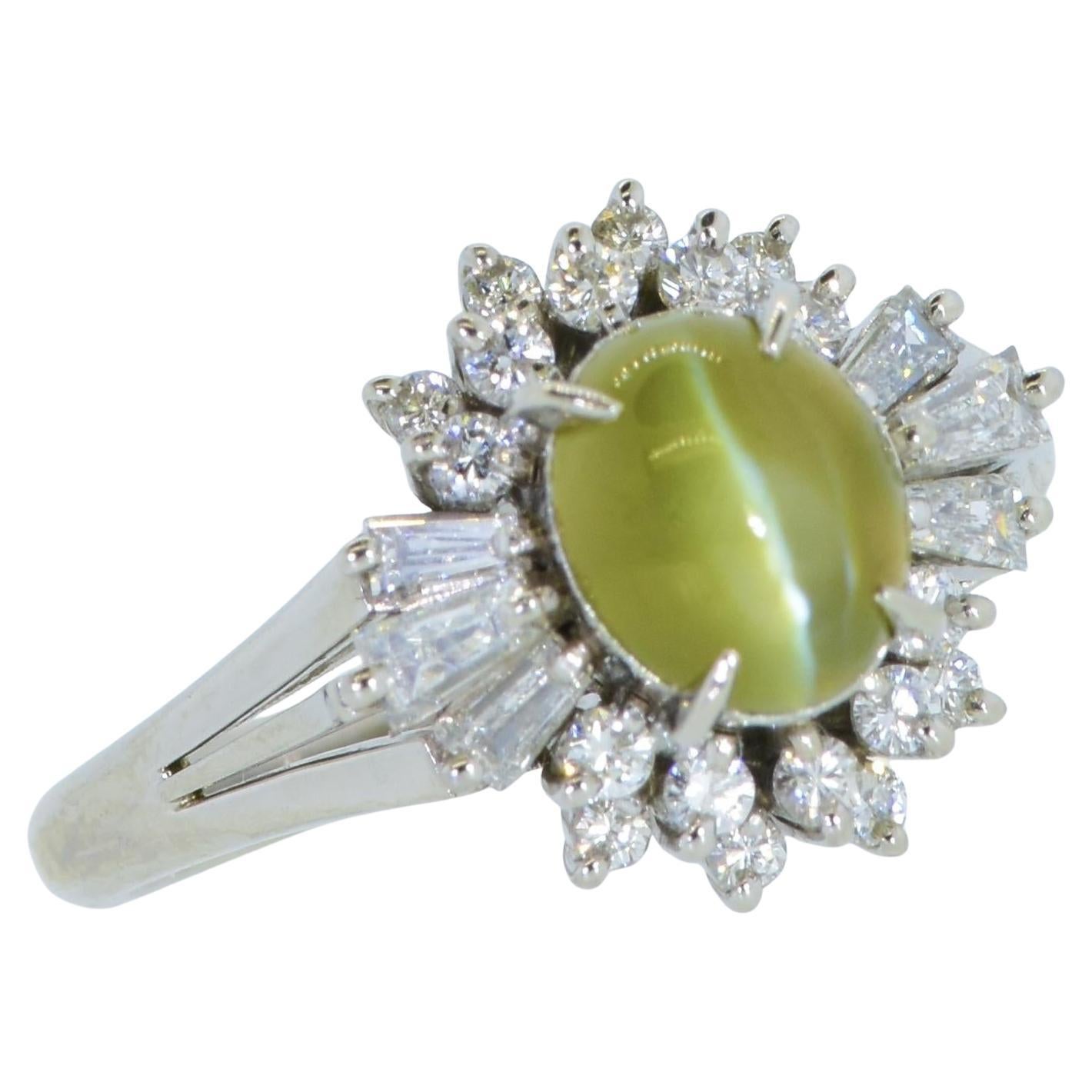 Very fine natural cat's eye chrysoberyl with an intense color, white diamond and platinum vintage ring. The center oval stone is a fine natural golden honey/green cat's eye chrysoberyl.  Many Cat's Eye Chrysoberyl stones are a diluted color with an