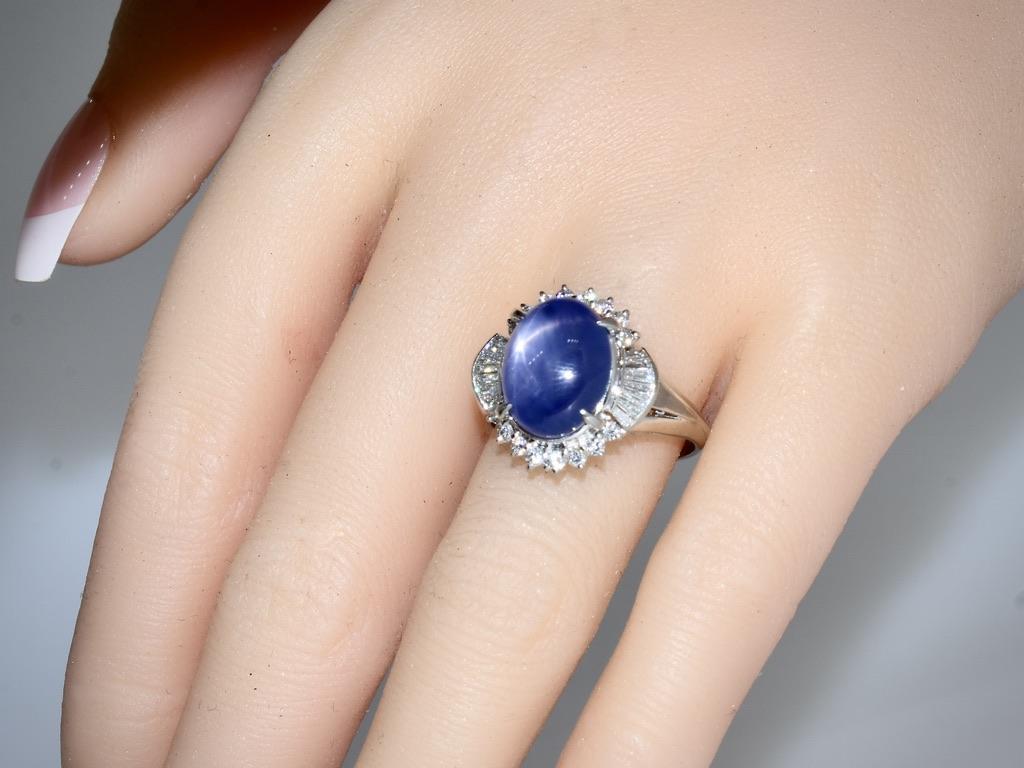 Very fine large natural star sapphire weighing exactly 11.74 cts. This oval stone, held by four long well shaped prongs, has a medium deep blue color. The distinct star is created naturally, in the sapphire crystal, of needle like silk inclusions