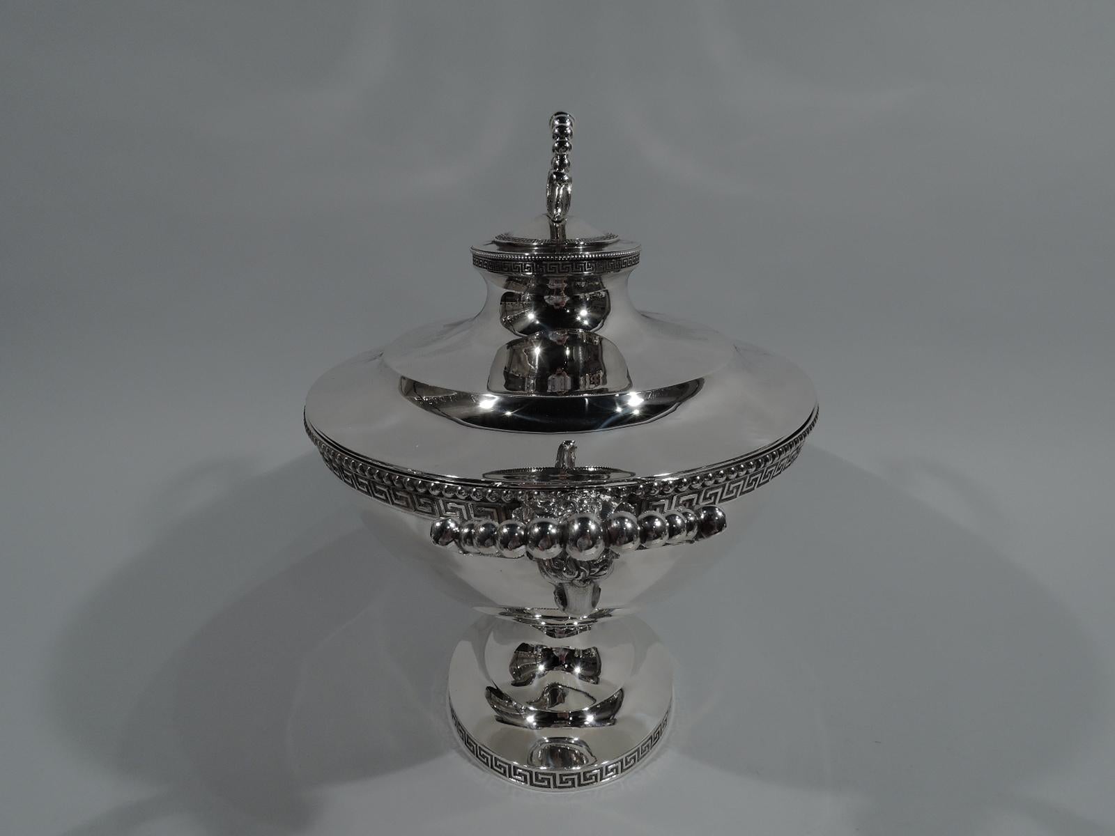 Greek Revival sterling silver soup tureen. Made by John C. Moore for Tiffany & Co. at 550 Broadway, New York. Ovoid bowl has leafy-ring end handles with graduated beading fix-mounted to cast ram’s heads. Cover stepped and domed with same.