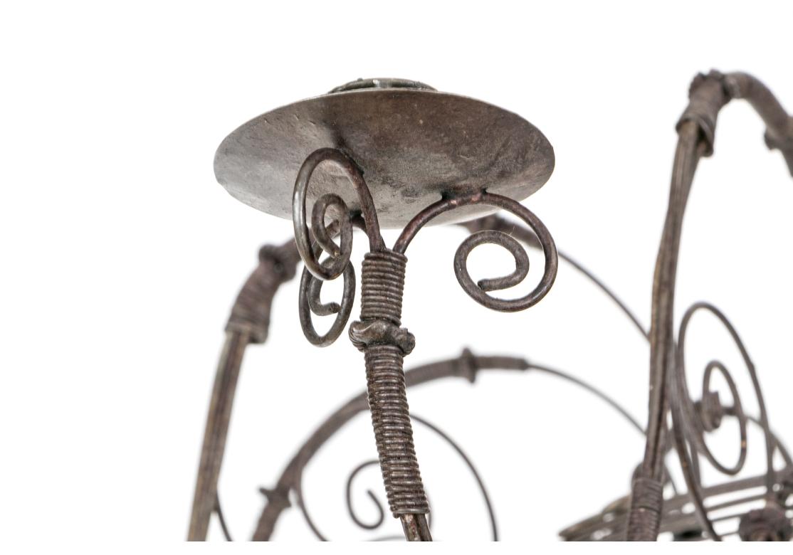 Fine French Country Wire chandelier featuring eight swooping S-curve arms detailed with scrolled motifs around simple candle sconces. The arms emerge from a shapely inverted gourd or beehive form with concentric circular bands graduating to the