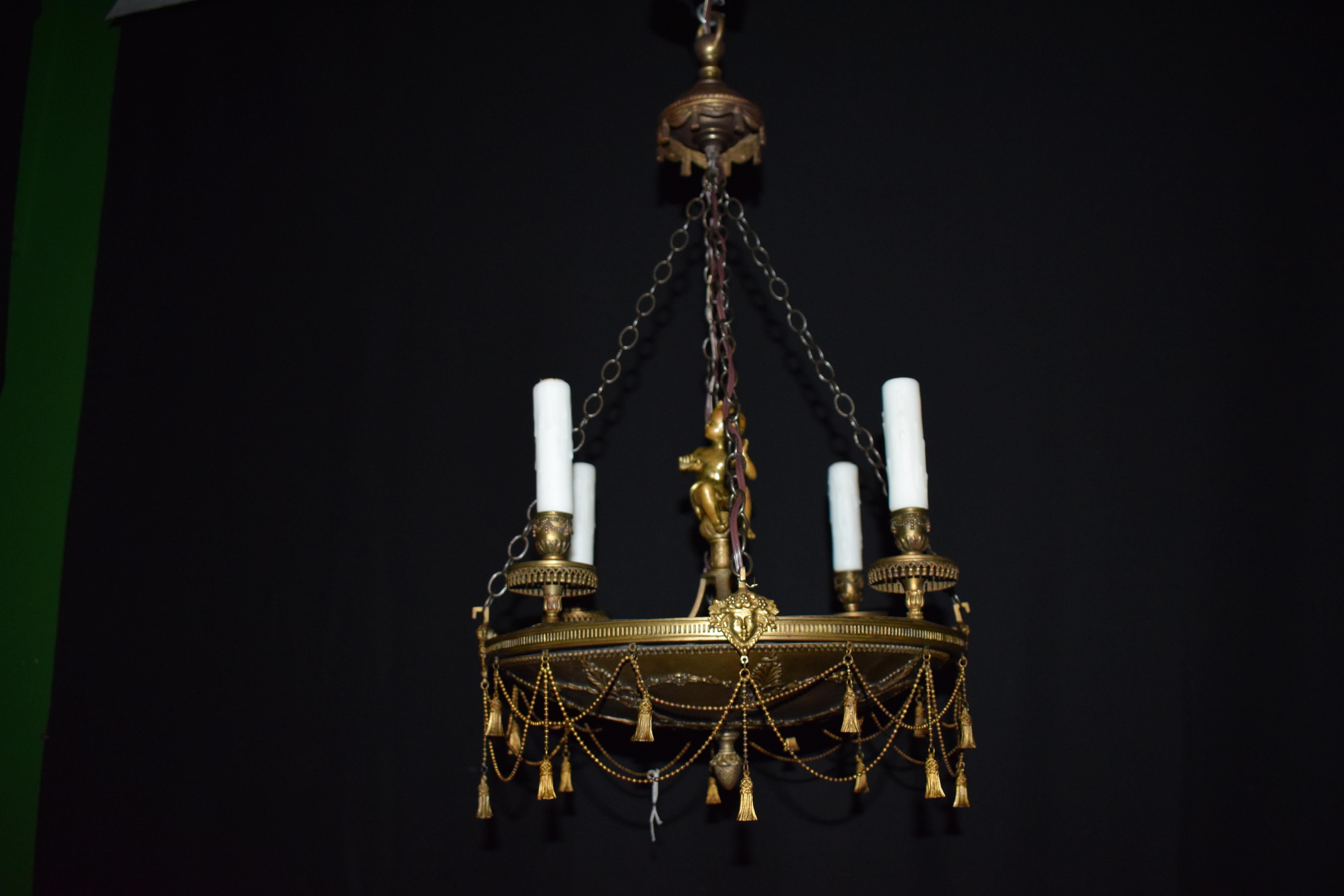 Un très élégant lustre de style empire en bronze doré. Détail exquis. 4 lumières.
France, vers 1920. Mesures : Hauteur 27 1/2