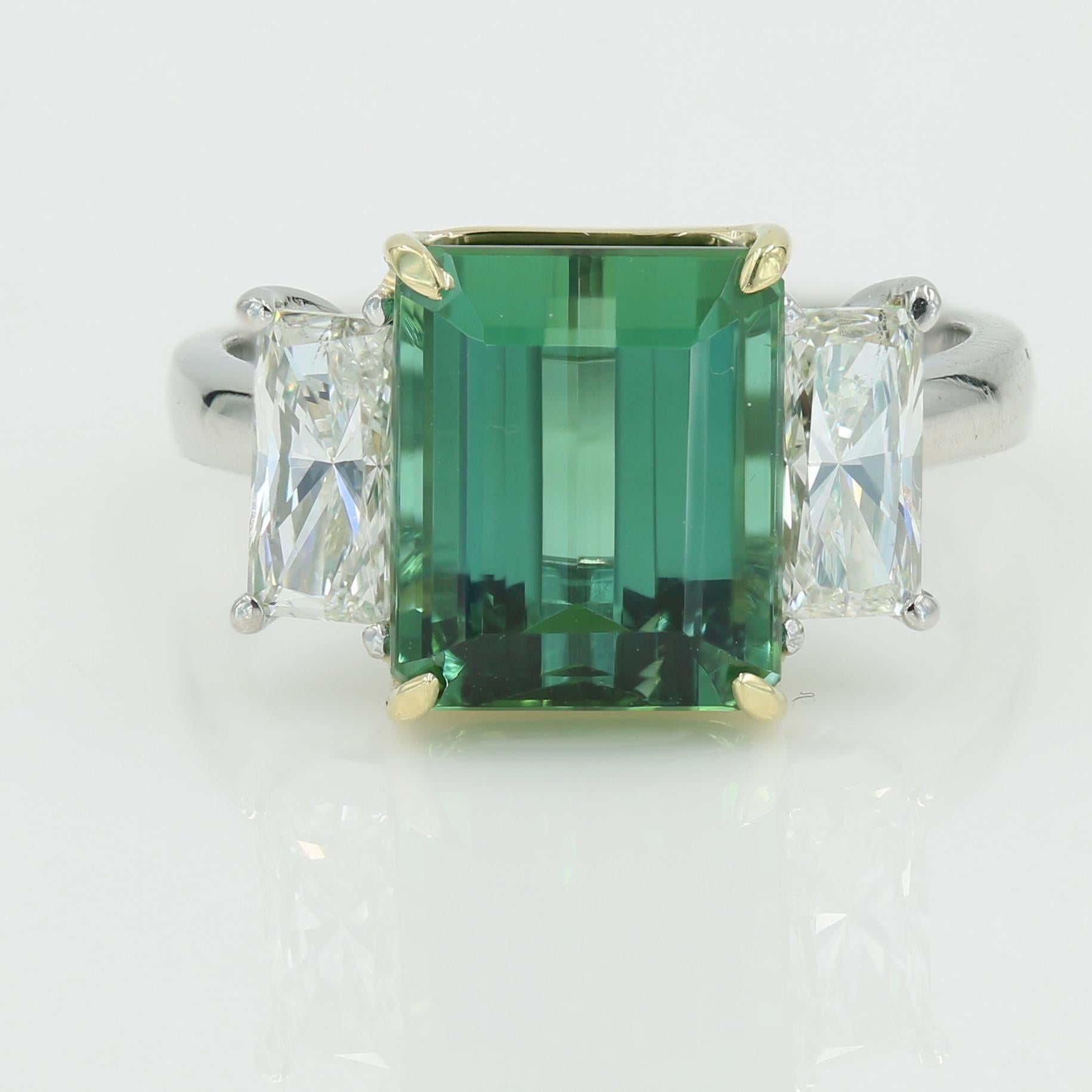 Very Fine Emerald Cut Natural Green Tourmaline weighing 4.81cts. set in a Platinum & 18kt Yellow gold setting with 2 rectangular shaped princess cut diamonds = 1.00tw (I-J SI2) - Mtg is Pre-owned

Finger size is 5 1/4 - can be sized if needed.