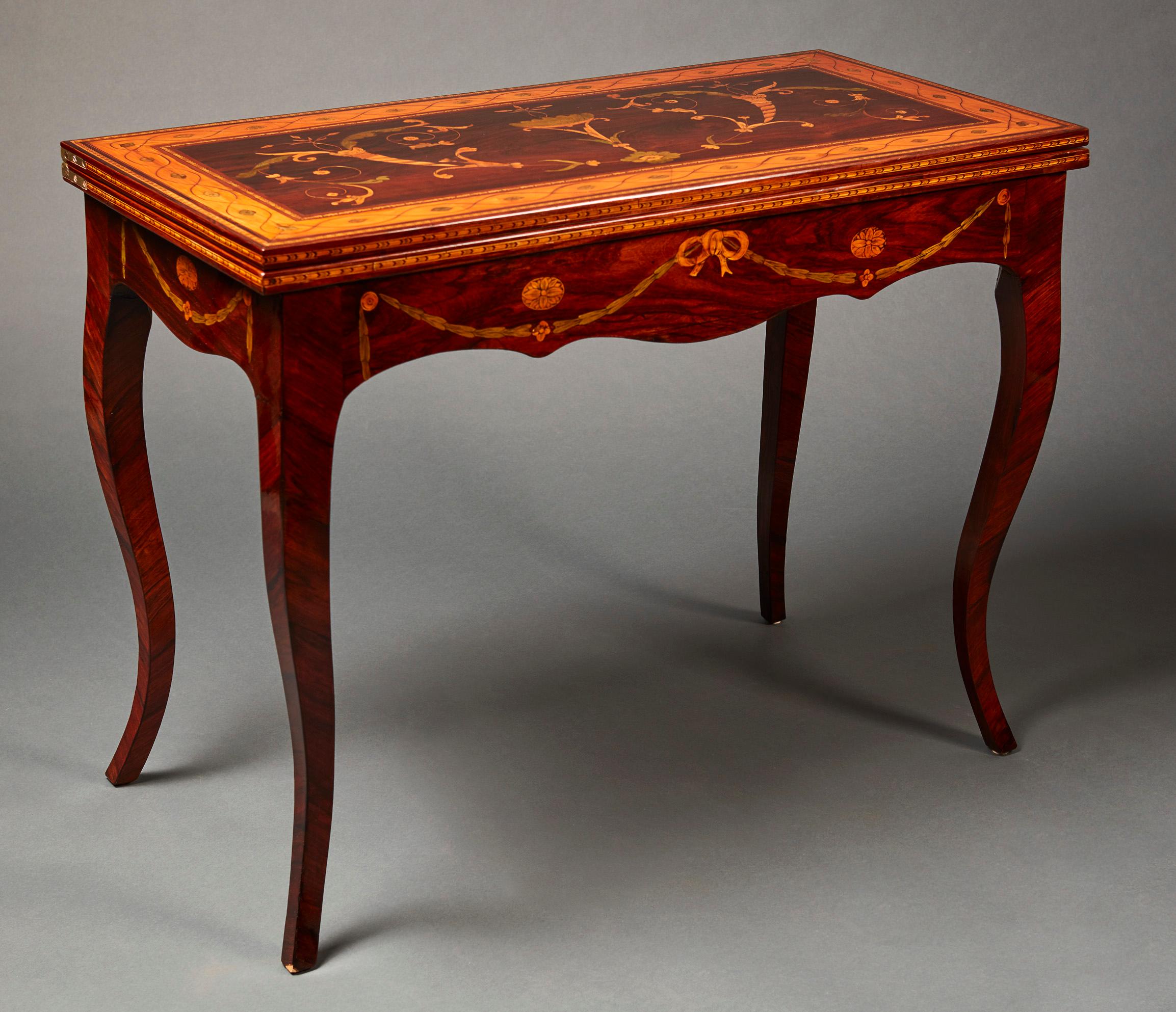 A fine neoclassical Russian fruitwood marquetry and parquetry games table from the late 18th century, probably Saint Petersburg. With a rectangular rotating and folding top, decorated with elaborate rinceaux scrolling foliage, opening to a