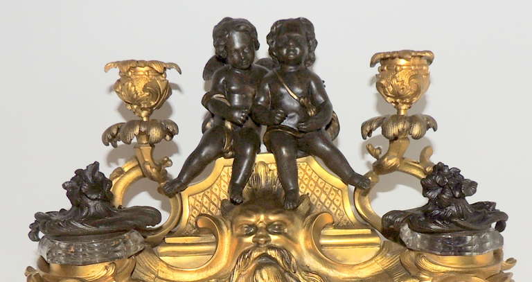 Äußerst feine, zweifarbig dorierte Bronze mit originalen Kristalltintenfässern und Tinteneinsätzen, F. Linke zugeschrieben. Die beiden Putten sitzen auf dieser schönen Bronzefigur, die rundum mit Details versehen ist und von Kandelabern flankiert