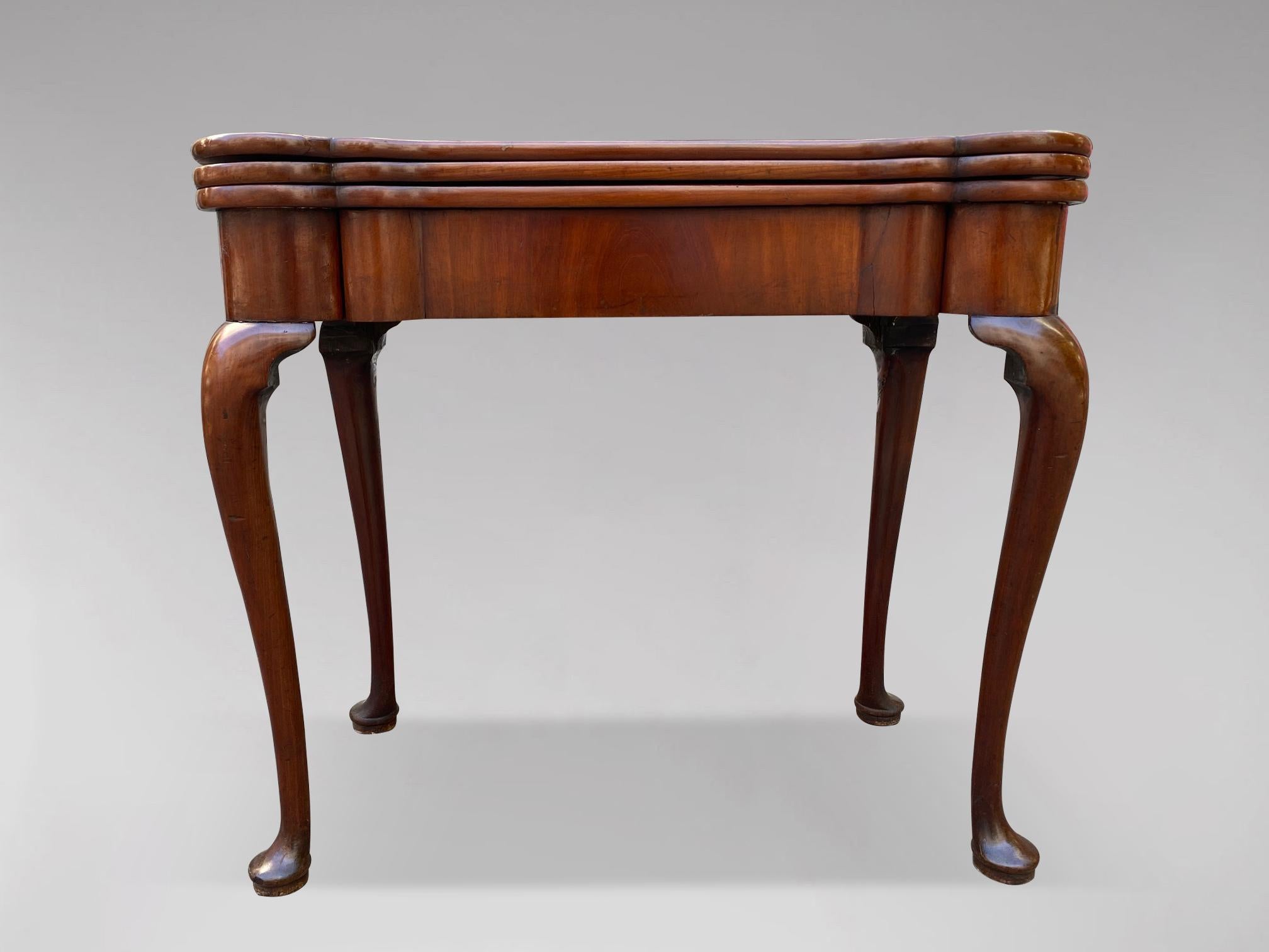 A stunning 18th century George II period mahogany triple fold over top card, tea or gaming table. The beautifully shaped Cuban mahogany top raised on shapely cabriole legs with ‘lappet’ carved knees and pad feet, the frieze fitted with a single