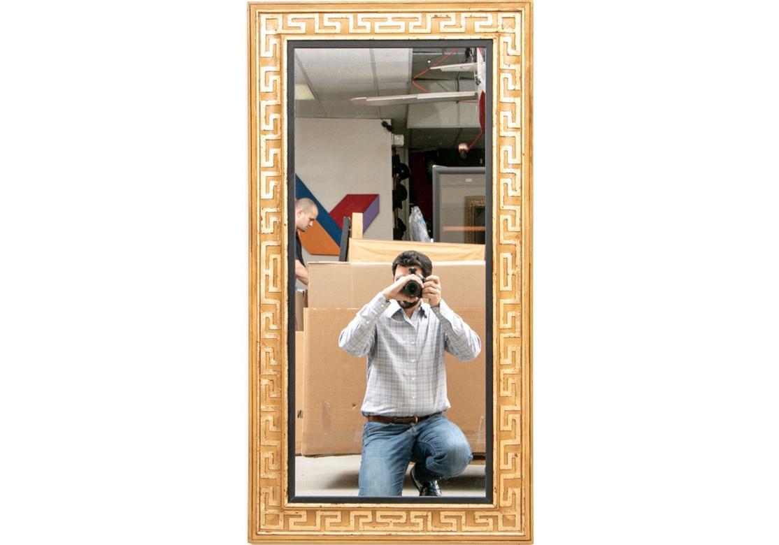 Very fine and well made wall mirror with a light wood or faux grain painted frame and having a raised Greek Key motif on the surround. The gilding is nicely worn with spots of the underlying red clay showing through to excellent effect. The mirror