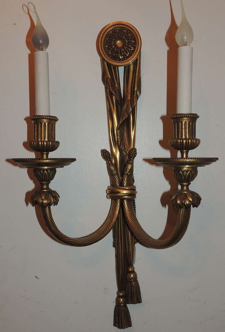 A very fine detailed pair of E.F. Caldwell gilt bronze, tassel two-light sconces in the neoclassical style, circa 1920s.