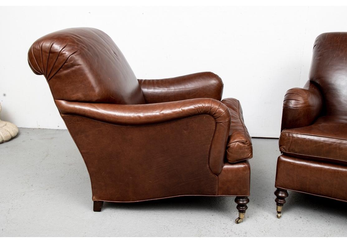 A pair of Edward Ferrell Club chairs impeccably upholstered in a rich Chocolate Brown Leather. Large, accommodating , solid feeling and very comfortable. The curved arms and backs have simple pleats on the corners and the Chairs have wood turned