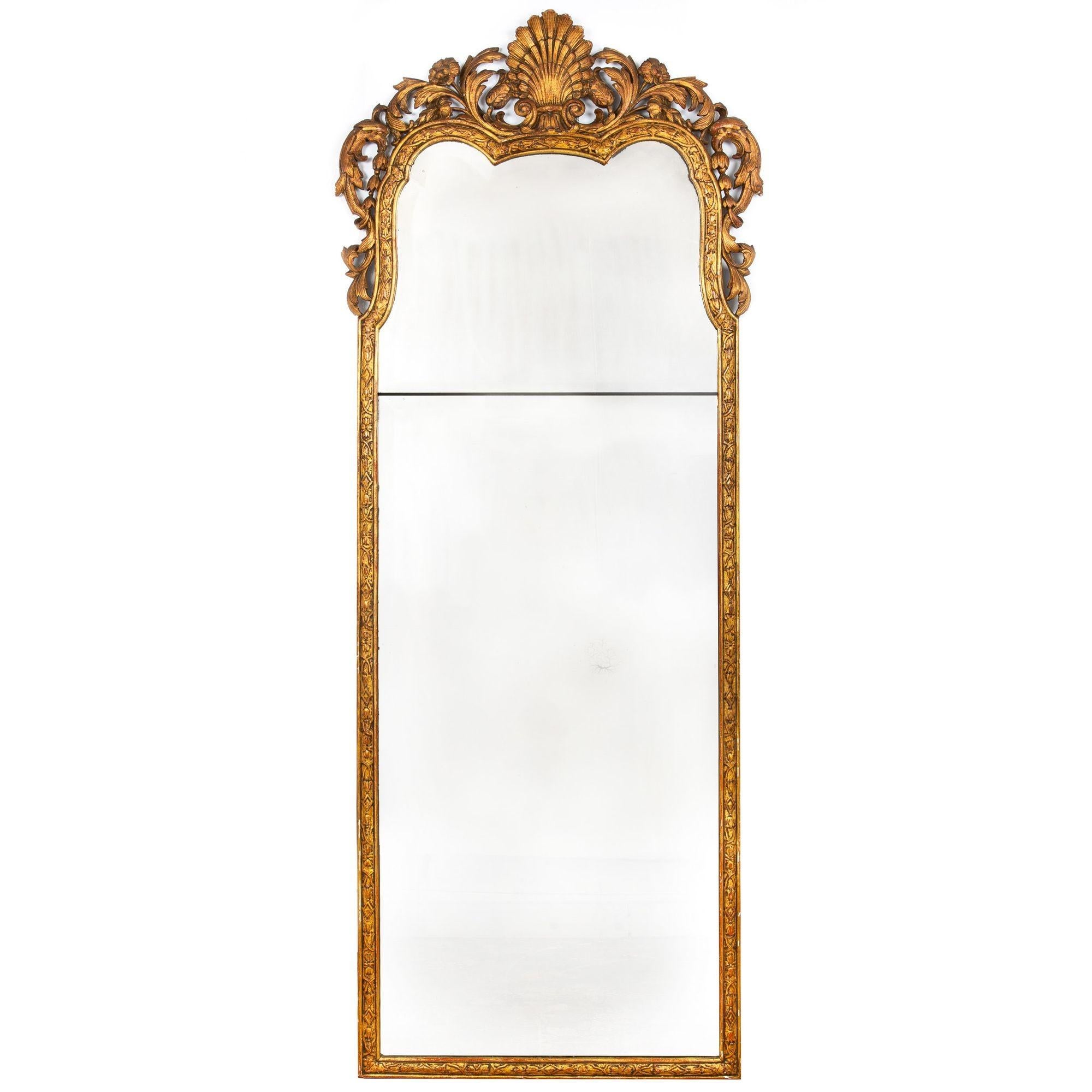 An exceedingly fine pair of giltwood mirrors, they are perfectly matched and feature a rich surface patina from centuries of life and gentle handling. Much of the original gilding is retained in the frames, this rubbed away to reveal rich tones of