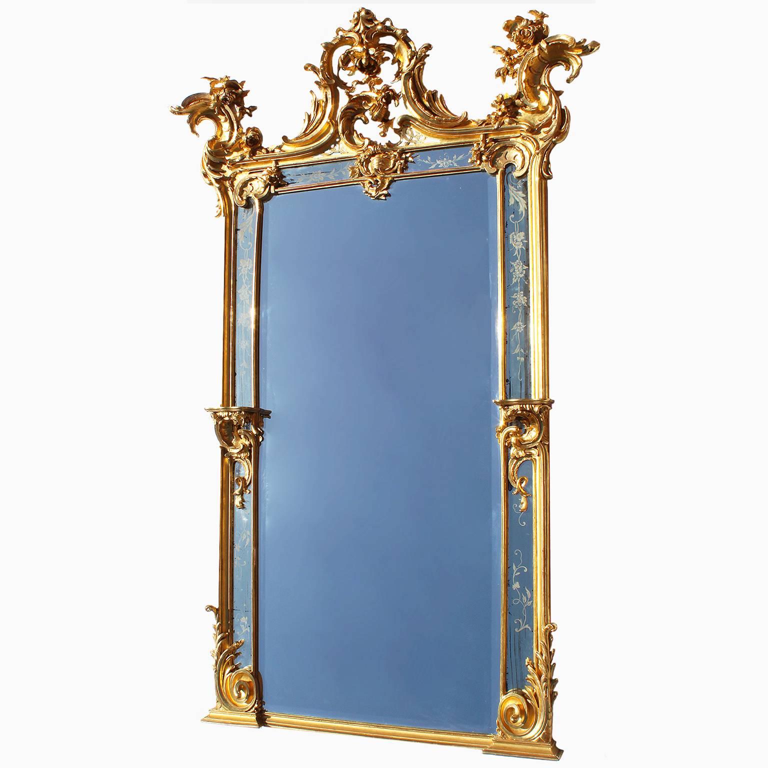 A very fine and important pair of French 19th century Rococo Revival style giltwood carved pier mirrors. The elongated intricately carved frames with carvings of tropical flowers, scrolls, seashells and acanthus, flanked on each side by a pair of