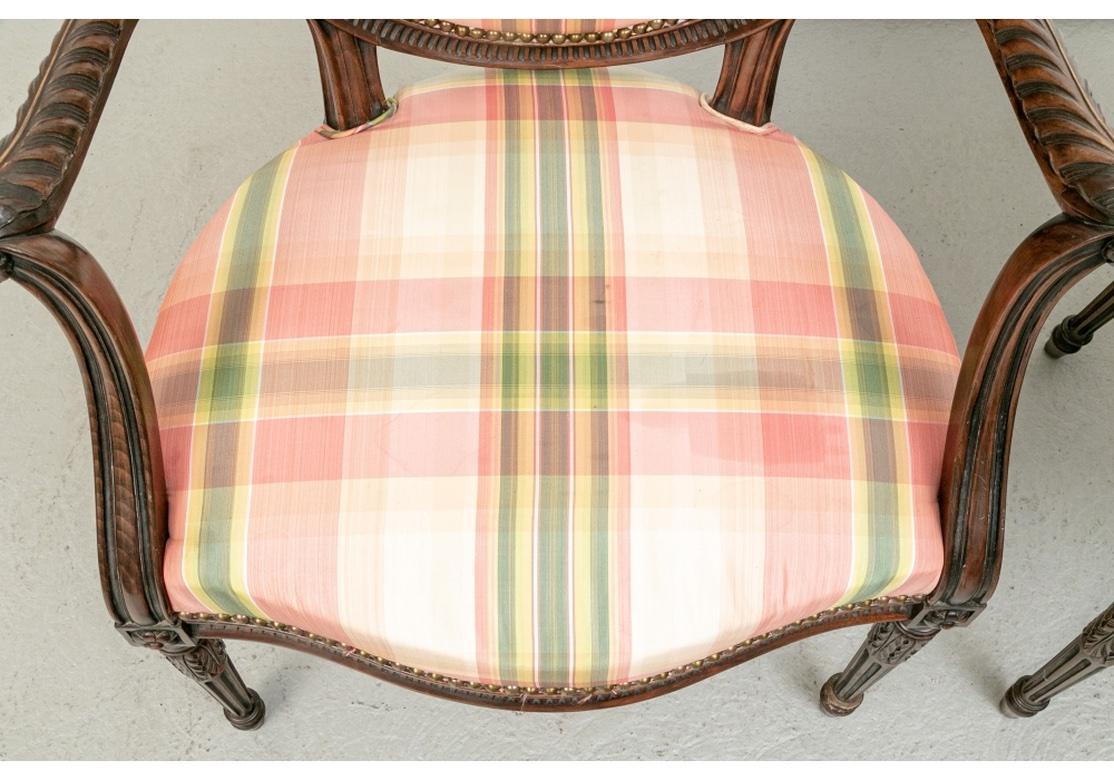 Une paire particulièrement bien faite de  Fauteuils à dossier ovale aux proportions généreuses, teinture profonde, cadres sculptés sophistiqués, pieds cannelés effilés et une forme sinueuse saisissante. La paire est tapissée sur mesure d'une soie ou