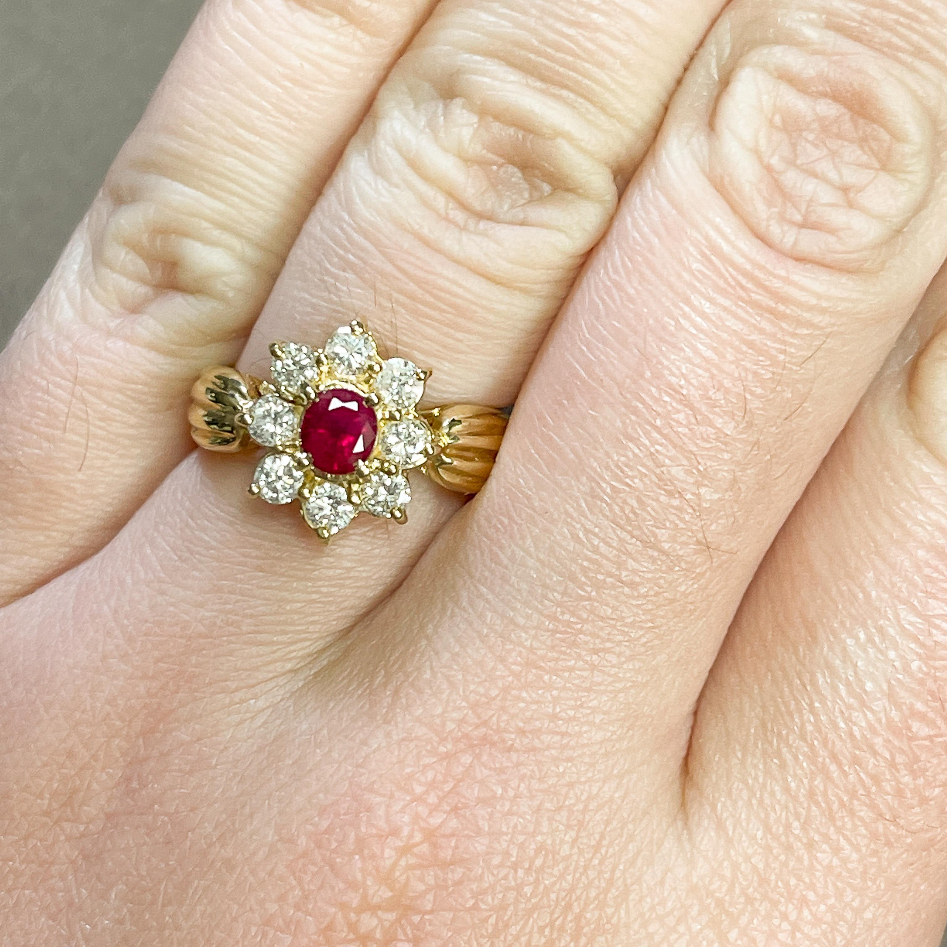 Beautiful women's floral ring! The ruby center is a deep red accented by 8 round cut diamonds. The yellow gold band has ridges like a floral stem. Rubies symbolize love, passion, and commitment. They are also the birthstone for July. 

• 18k Yellow