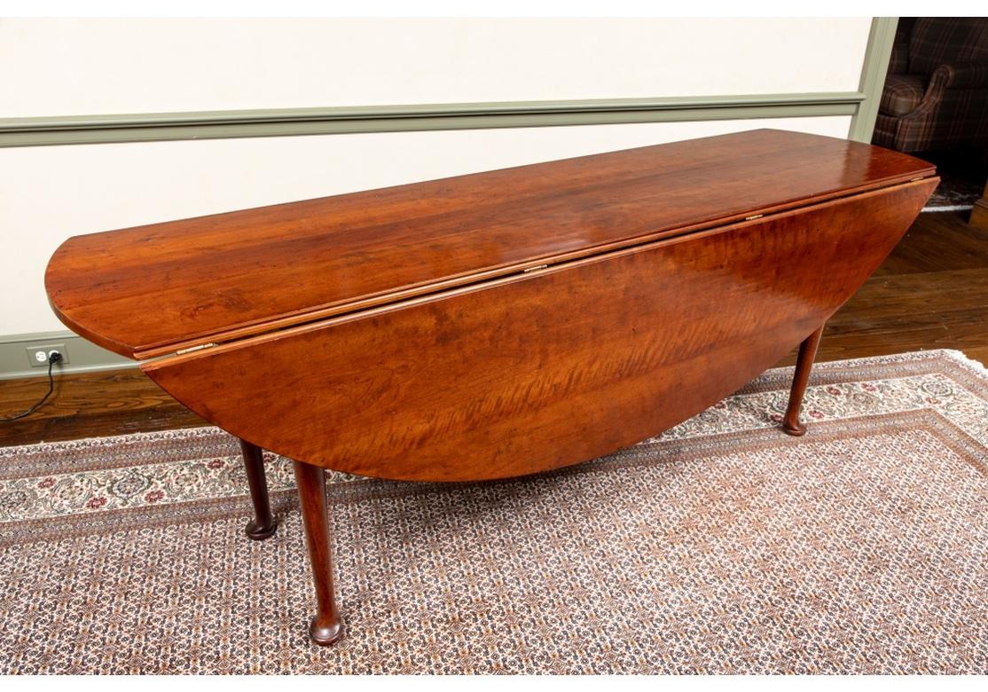 A beautifully proportioned and very well-made and finished Oval Mahogany Harvest Table. A fine drop leaf dining or harvest table with oval form and resting on pad feet. Particularly striking when open. 
Dimensions: 84