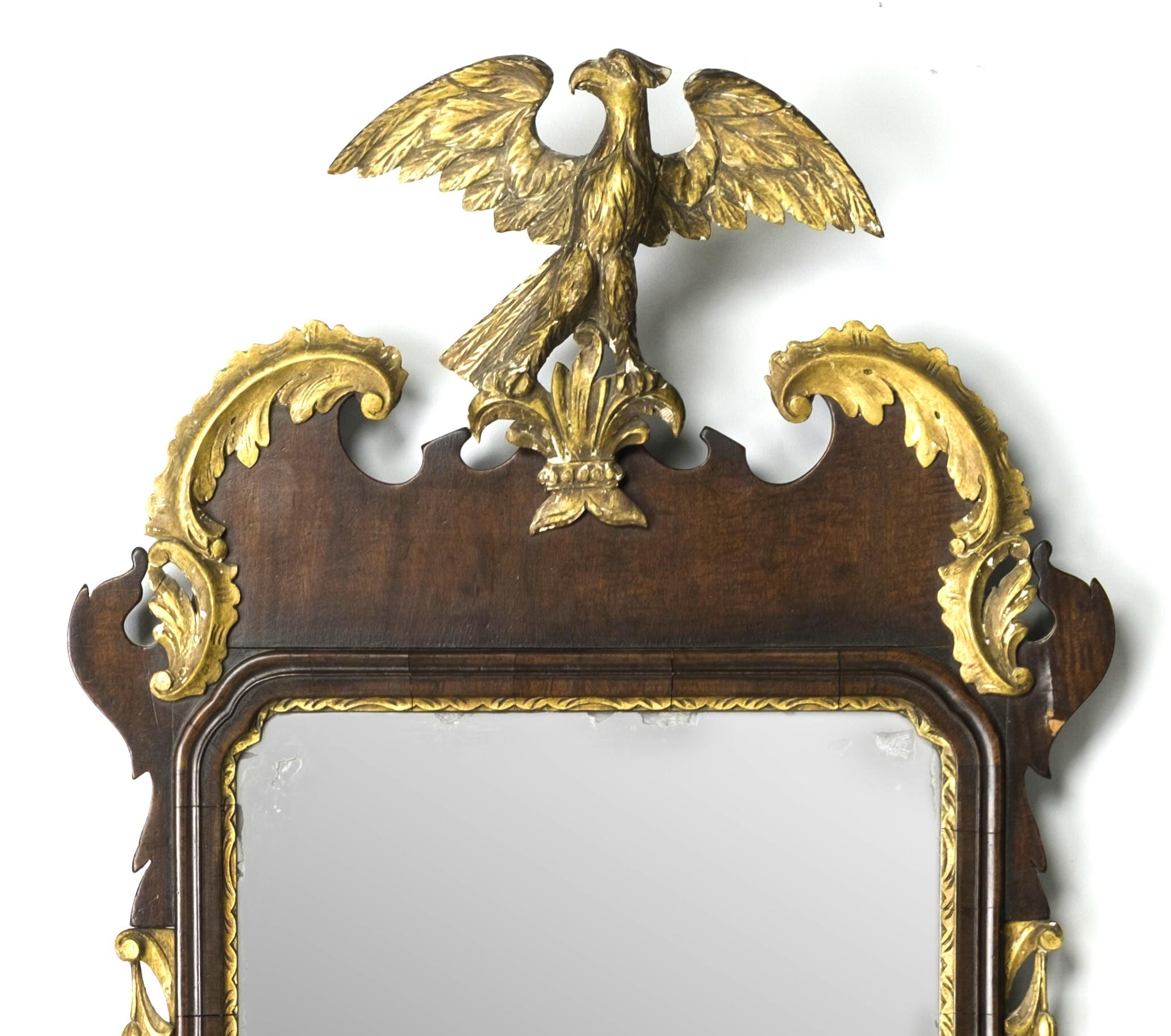 A very handsome centennial Constitutional, Chippendale style looking glass / pier mirror showing an old if not original rectangular plate set within solid mahogany moldings on a mahogany veneered frame, the pediment showing a hand carved & gilded